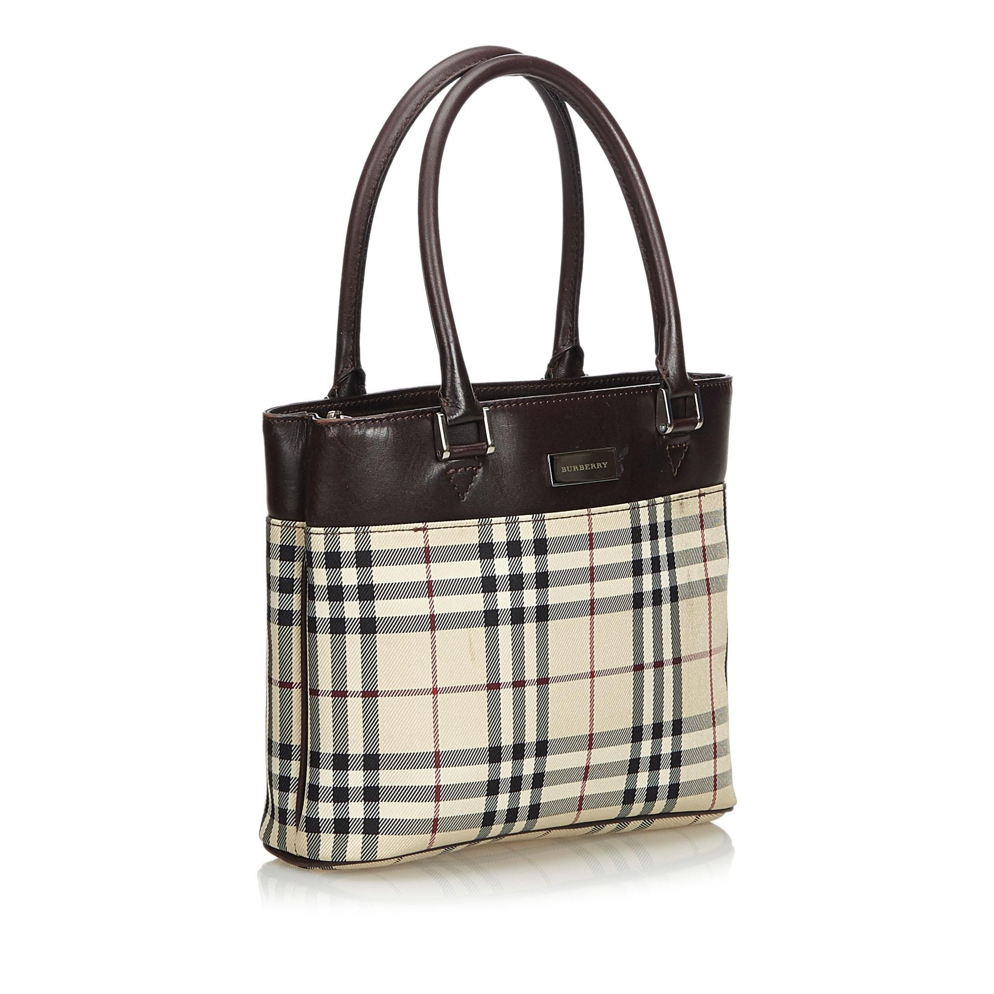 This handbag features a plaid jacquard body with leather trim, an external slip pocket, rolled leather handles, a top zip closure, and an interior pocket. It carries as B+ condition rating.

Inclusions: 
This item does not come with