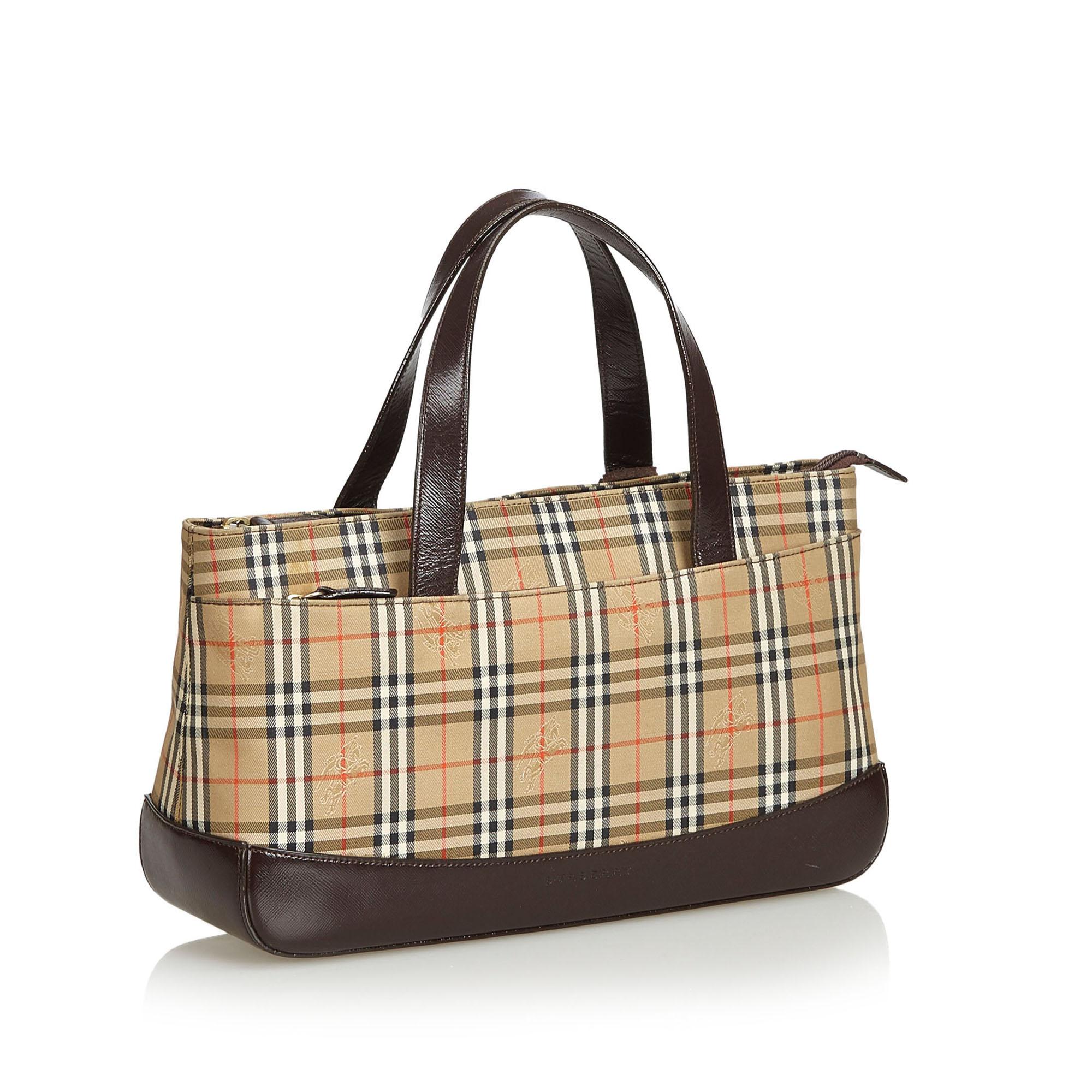 This handbag features a plaid nylon body with leather bottom, flat leather straps, open top, exterior slip pocket, and interior zip compartment and zip and slip pockets. It carries as AB condition rating.

Inclusions: 
This item does not come with
