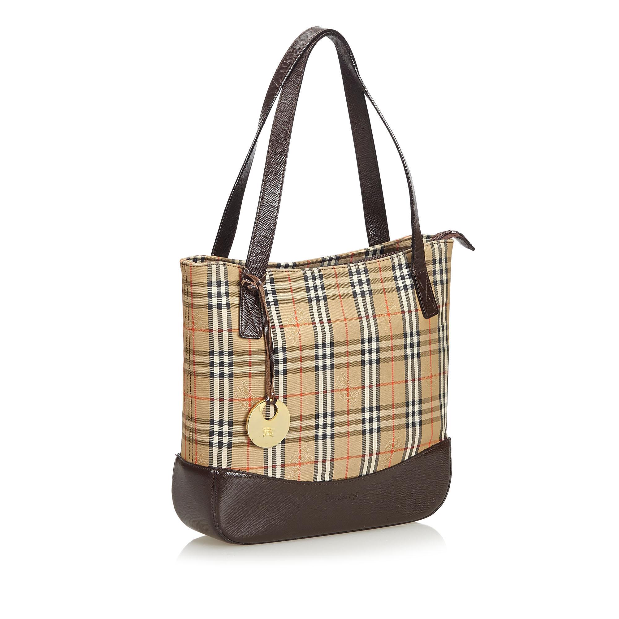 This tote bag features a canvas body with leather trim, flat leather handles, top zip closure, exterior slip pocket, and interior zip and slip pockets. It carries as B+ condition rating.

Inclusions: 
This item does not come with