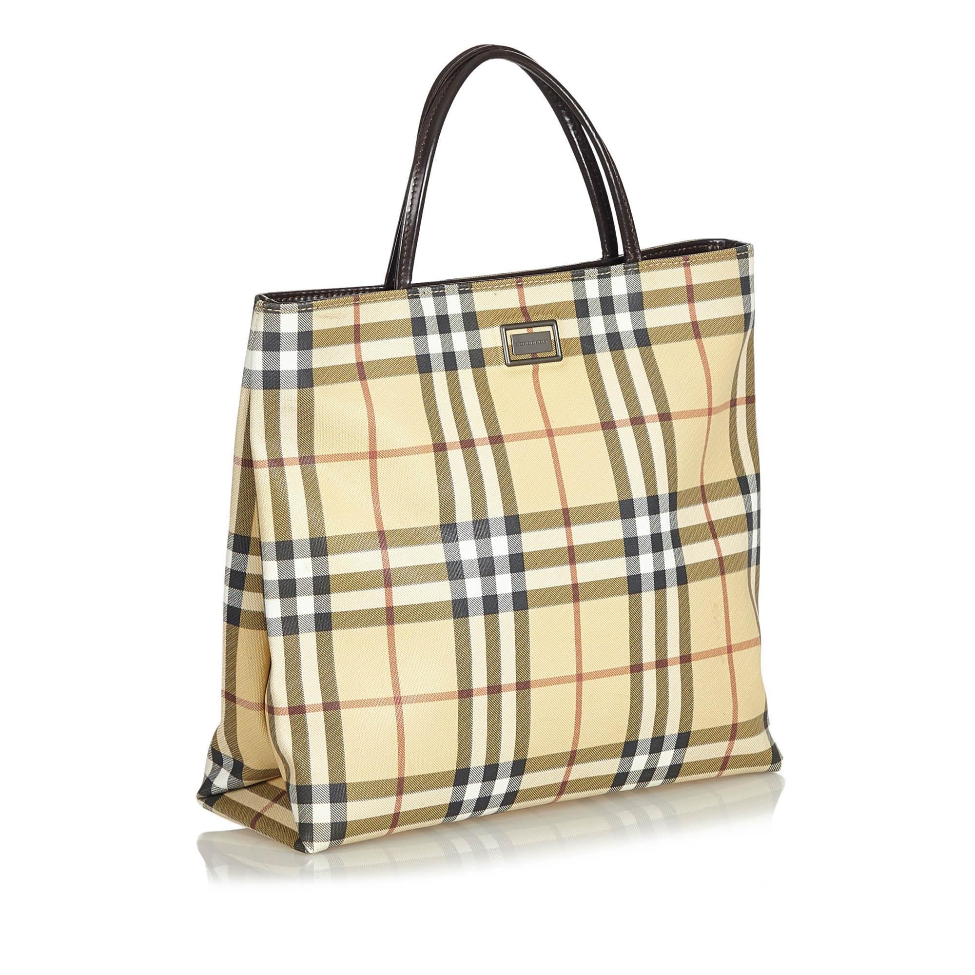 This tote bag features a plaid canvas body, flat leather handles, open top and interior zip pockets. It carries as B condition rating.

Inclusions: 
This item does not come with inclusions.

Dimensions:
Length: 26.00 cm
Width: 31.00 cm
Depth: 10.00