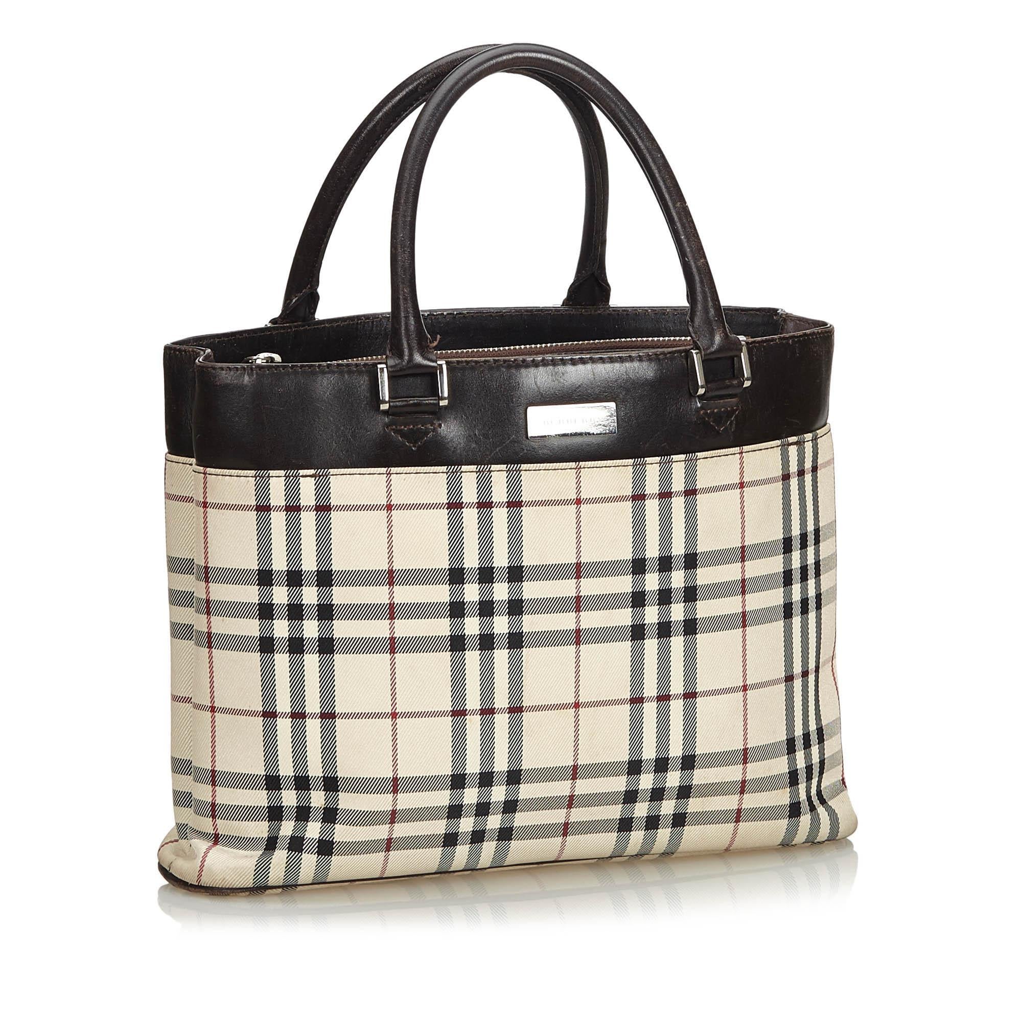 This tote features a coated canvas body with leather trim, rolled leather handles, open top and interior zip compartment and interior slip pocket. It carries as B condition rating.

Inclusions: 
This item does not come with