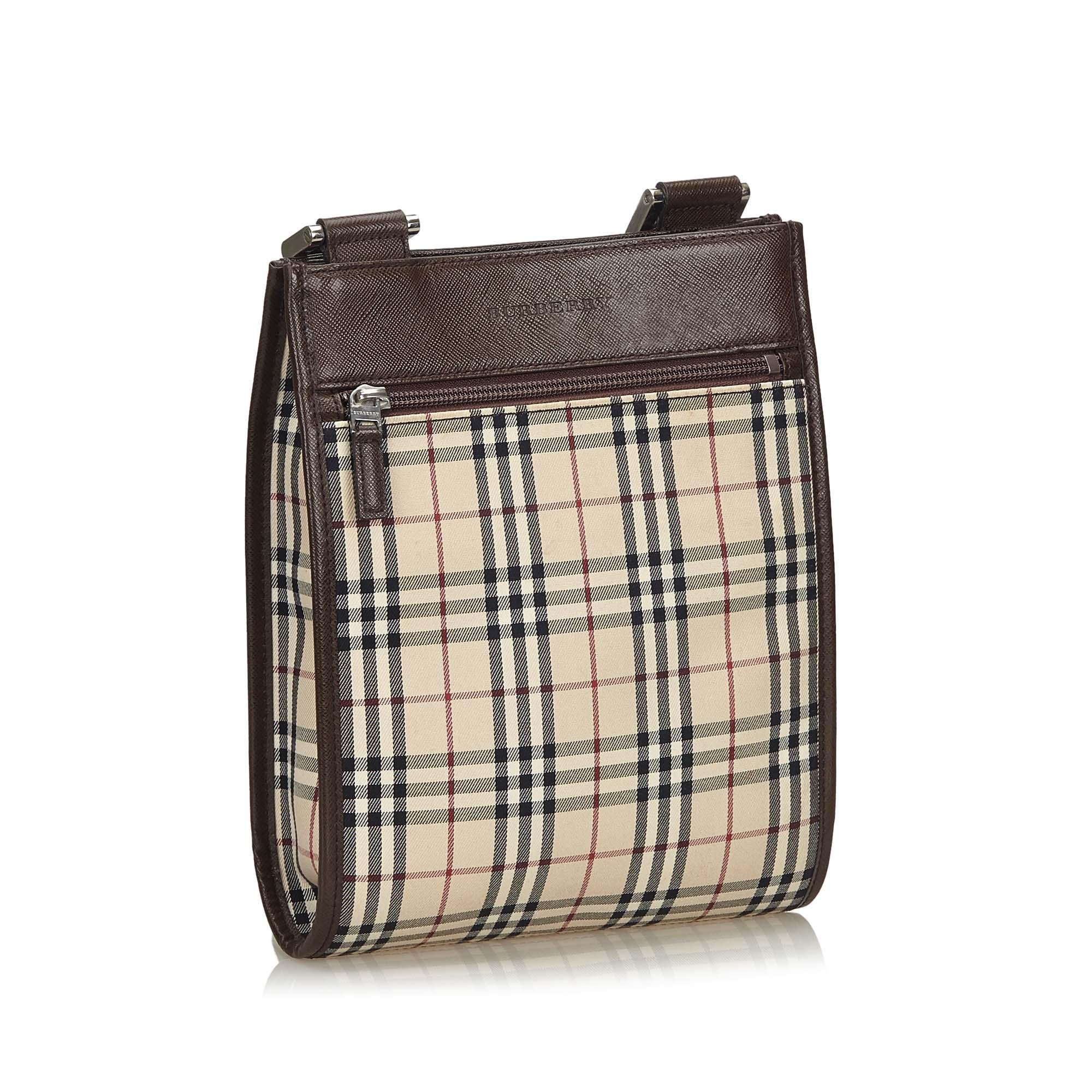 This crossbody bag features a plaid nylon body with leather trim, a front exterior zip pocket, an adjustable flat strap, an open top with a magnetic closure, and interior zip and slip pockets. It carries as AB condition rating.

Inclusions: 
This