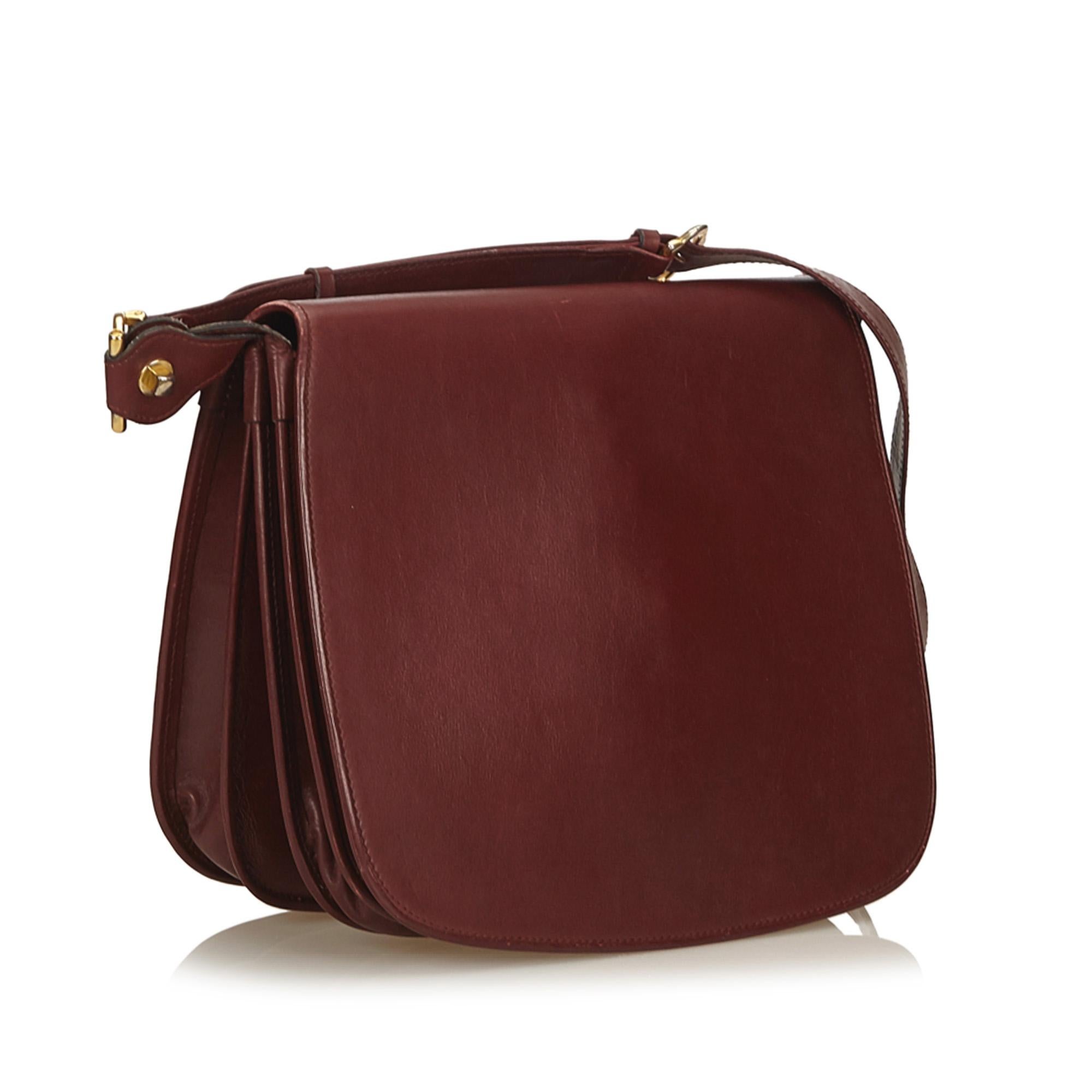 This shoulder bag features a leather body, gold-tone hardware, a flat shoulder strap, a front flap with a stud closure, interior open compartments, and an interior slip pocket. It carries as B condition rating.

Inclusions: 
This item does not come