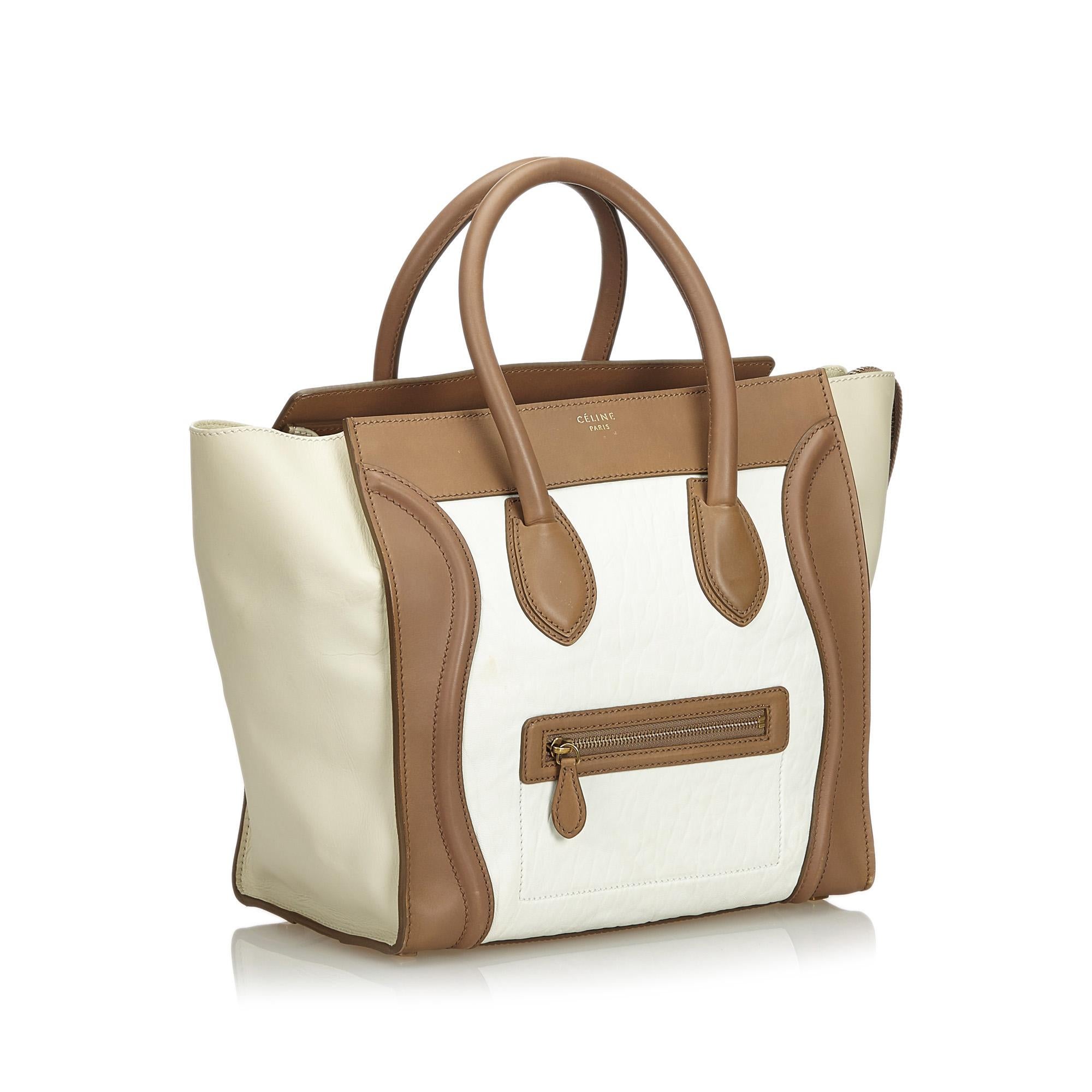 The Phantom tote bag features a leather body, a front exterior zip pocket, rolled leather handles, an open top, and interior zip pocket. It carries as B+ condition rating.

Inclusions: 
This item does not come with inclusions.

Dimensions:
Length: