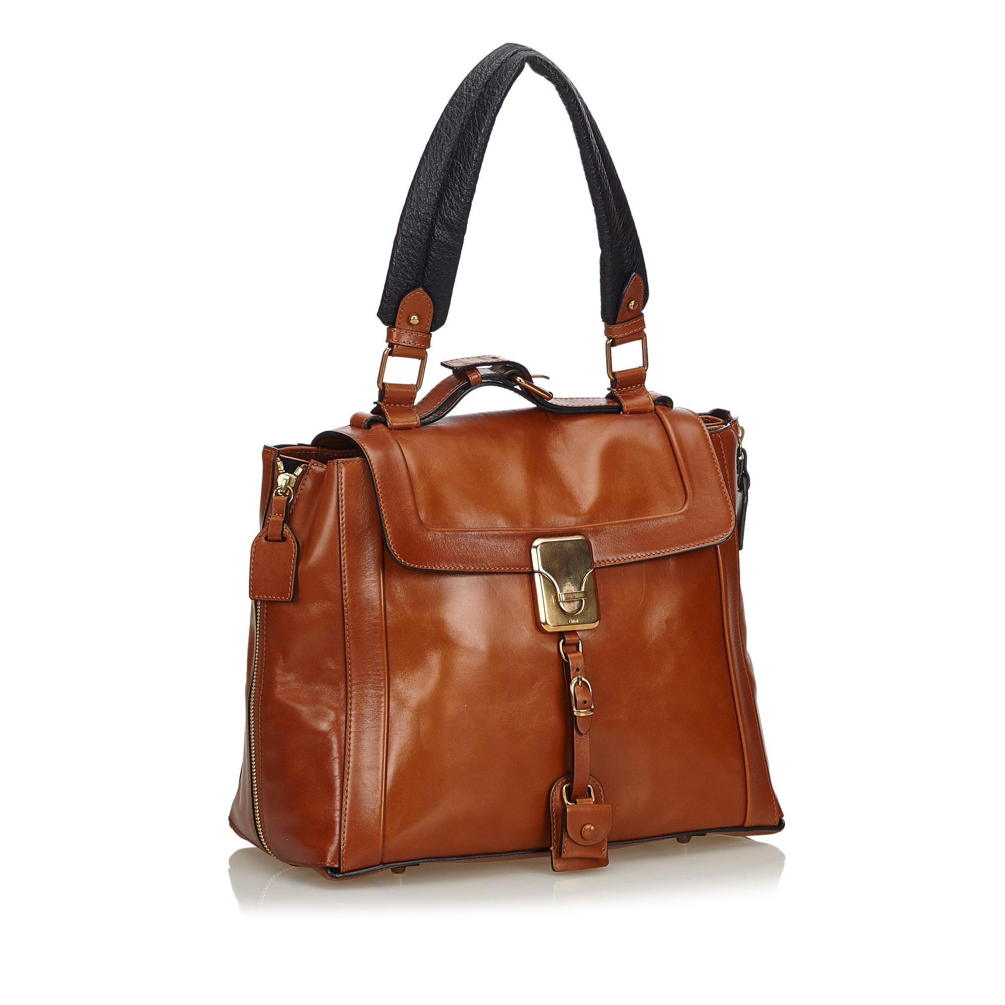This tote bag features a leather body with side zip details, a flat leather strap, a top flap with a metal closure, and an interior zip pocket. It carries as B+ condition rating.

Inclusions: 
This item does not come with