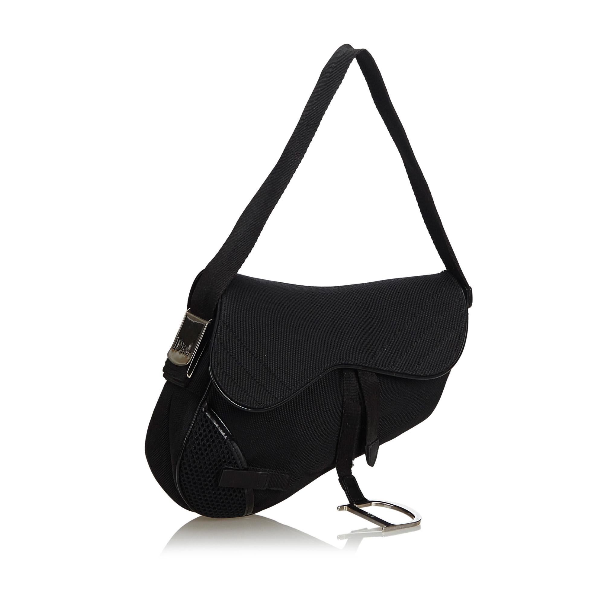 The Saddle features a nylon body, a back exterior mesh slip pocket, a flat strap, a top flap, and an interior zip pocket. It carries as B+ condition rating.

Inclusions: 
Dust Bag

Dimensions:
Length: 19.00 cm
Width: 26.00 cm
Depth: 5.50 cm
Shoulder