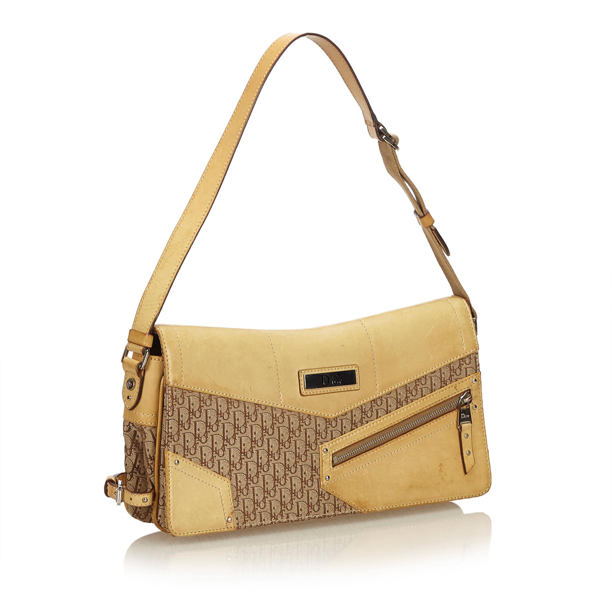 This shoulder bag features a canvas body with leather trim, flat leather strap, front flap with magnetic closure, exterior zip pocket and interior zip pocket. It carries as B condition rating.

Inclusions: 
This item does not come with