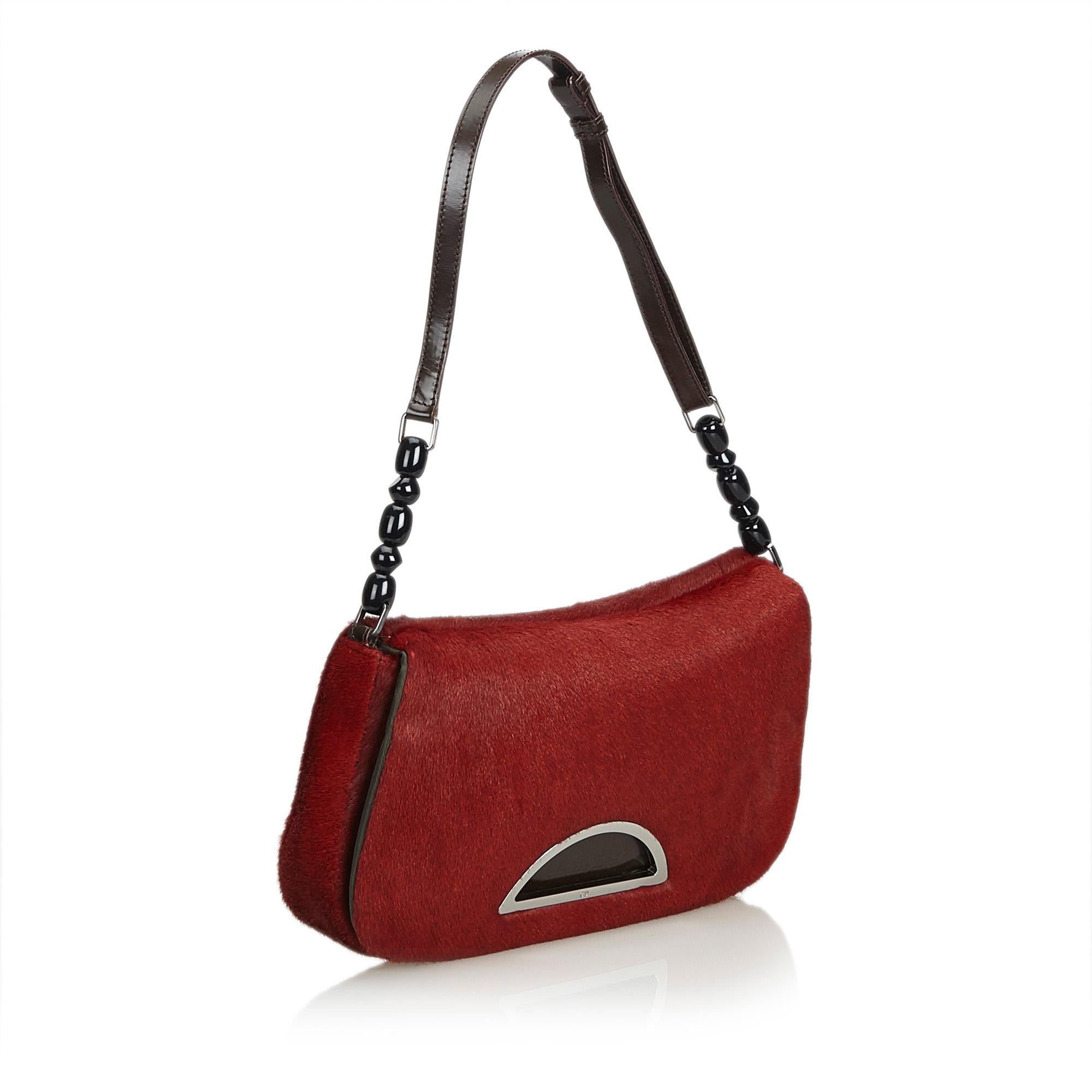 The Malice features a pony hair body, a leather shoulder strap, a front flap, and an interior zip pocket. It carries as B+ condition rating.

Inclusions: 
Dust Bag

Dimensions:
Length: 14.00 cm
Width: 26.00 cm
Depth: 4.00 cm
Shoulder Drop: 21.00