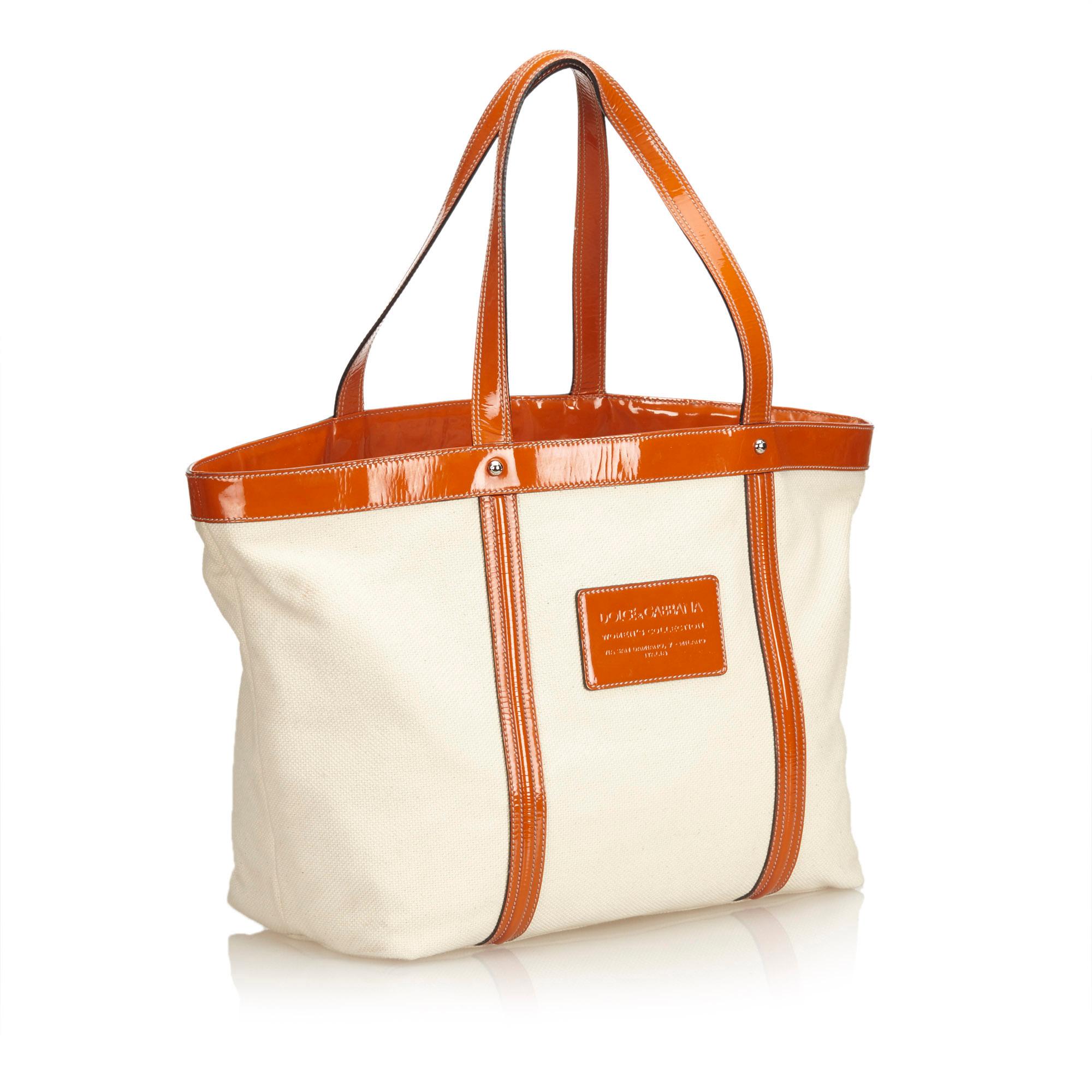 This tote bag features a canvas body with patent leather trim, flat leather straps, open top, and interior zip and slip pockets. It carries as AB condition rating.

Inclusions: 
Authenticity Card
Dimensions:
Length: 34.00 cm
Width: 38.00 cm
Depth: