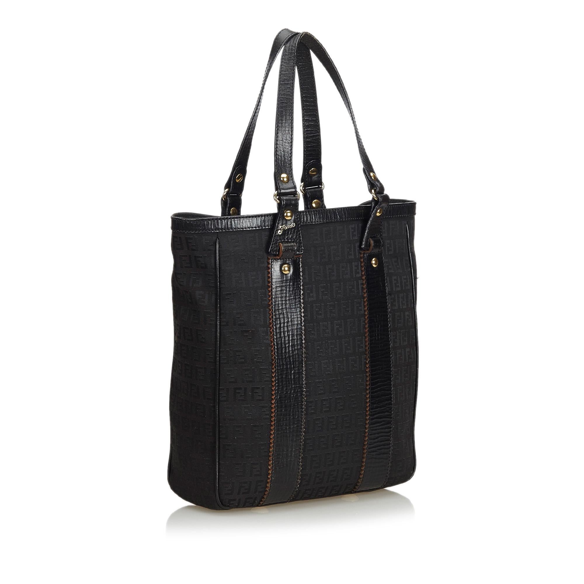 This tote bag features a canvas body with leather trim, flat leather straps, a top zip closure, and interior zip pockets. It carries as AB condition rating.

Inclusions: 
This item does not come with inclusions.

Dimensions:
Length: 34.00 cm
Width: