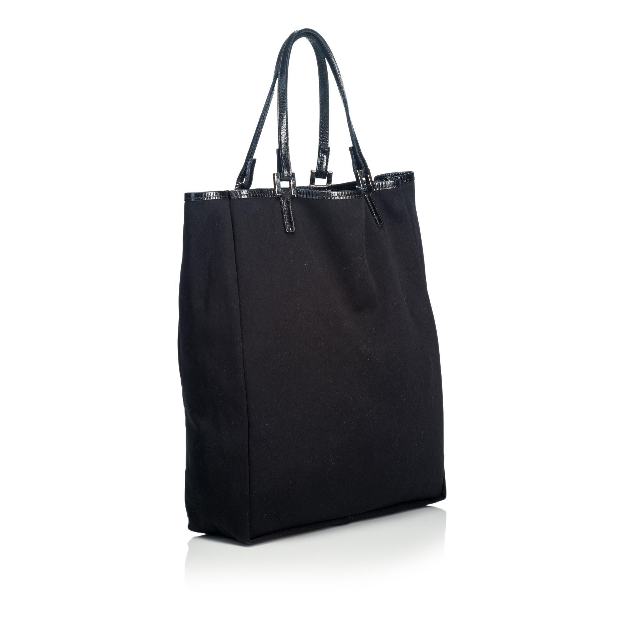 This tote bag features a cotton body with leather trim, flat leather straps, and an open top It carries as B+ condition rating.

Inclusions: 
Dust Bag

Dimensions:
Length: 30.00 cm
Width: 25.00 cm
Depth: 8.00 cm
Shoulder Drop: 13.00 cm

Material: