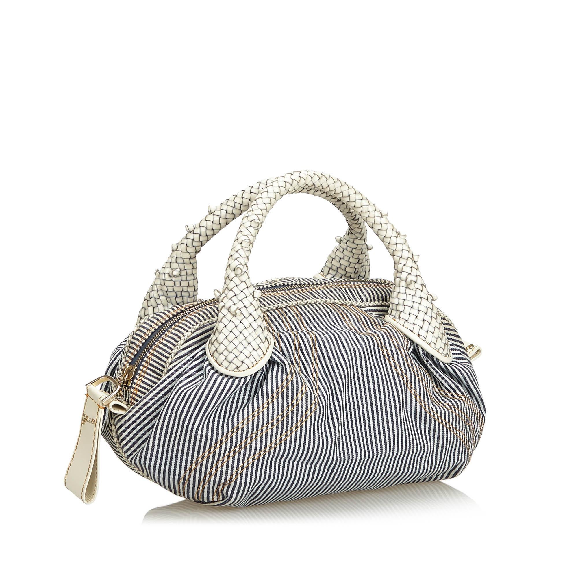 The Mini Spy handbag features a striped canvas body, woven leather handles, a top zip closure, and an interior slip pocket. It carries as AB condition rating.

Inclusions: 
This item does not come with inclusions.

Dimensions:
Length: 22.00