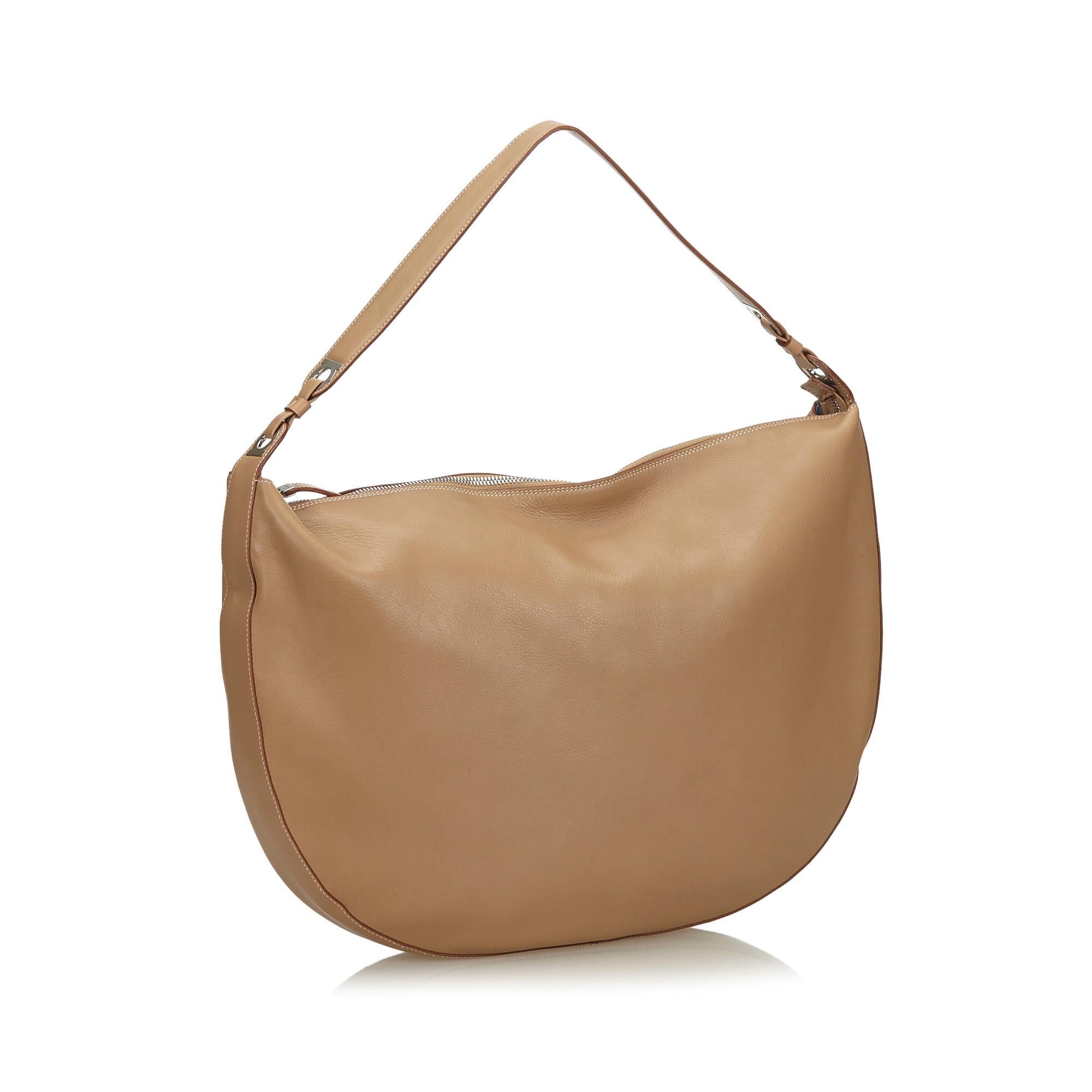 This shoulder bag features a leather body, a flat leather strap, a top zip closure, and an interior zip pocket. It carries as B condition rating.

Inclusions: 
Dust Bag

Dimensions:
Length: 33.00 cm
Width: 40.00 cm
Depth: 5.00 cm
Shoulder Drop: