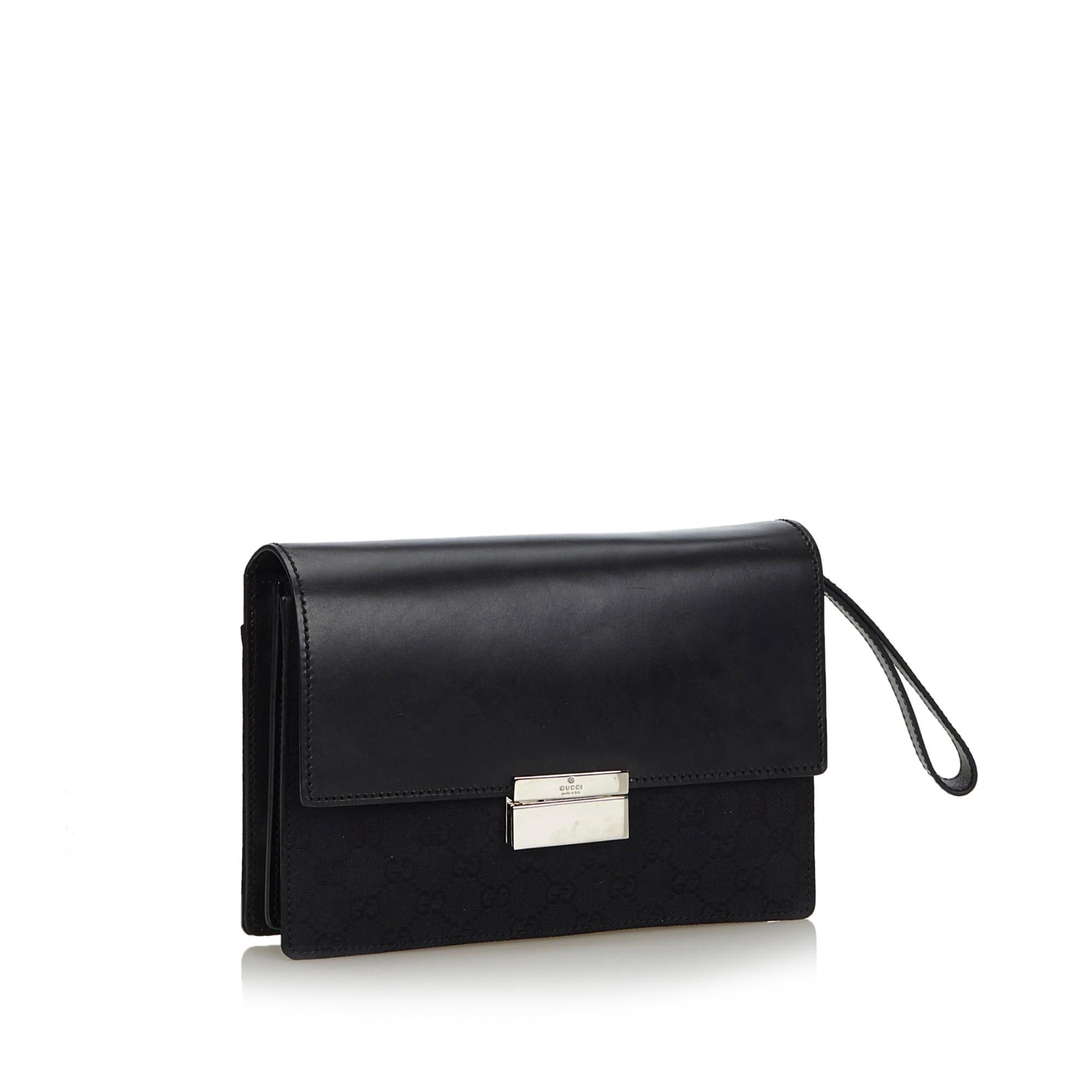 This clutch bag features a canvas body, a flat leather wrist strap, a front leather flap with a metal closure, and an interior zip pocket. It carries as AB condition rating.

Inclusions: 
Dust Bag

Dimensions:
Length: 18.00 cm
Width: 26.00 cm
Depth: