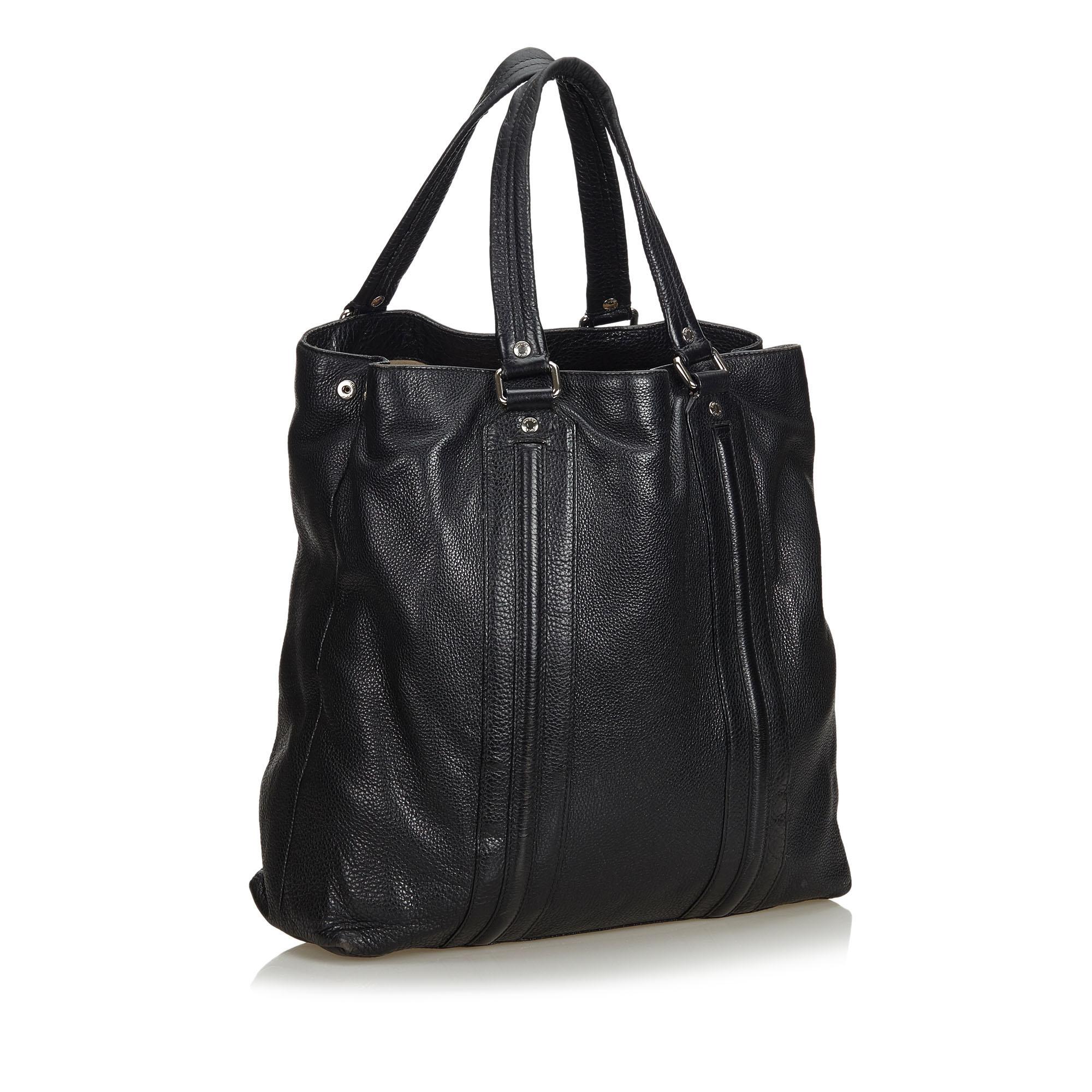 This tote bag features a leather body, flat leather straps, an open top with a magnetic snap button closure, and an interior zip compartment and pocket. It carries as B condition rating.

Inclusions: 
This item does not come with