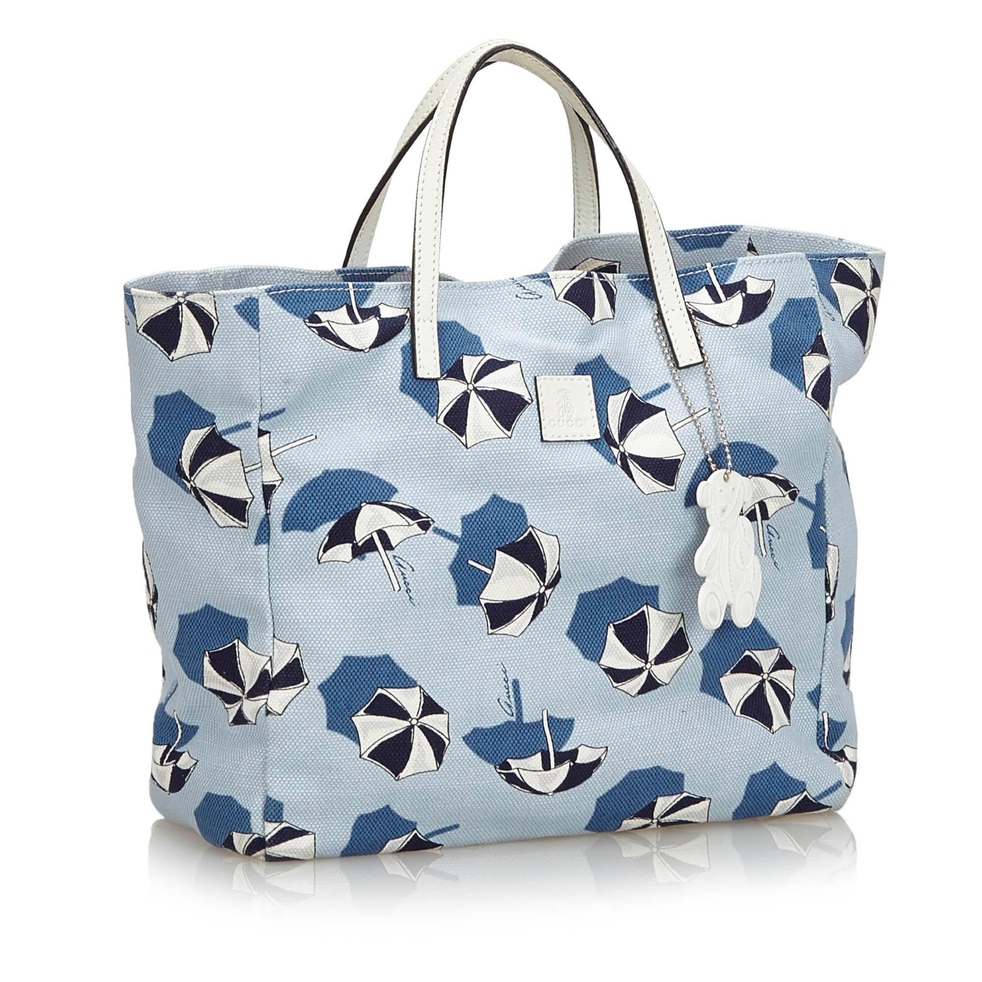 This tote bag features a printed canvas body with leather trim, flat leather straps, an open top, and an interior slip pocket. It carries as B+ condition rating.

Inclusions: 
Dust Bag

Dimensions:
Length: 21.00 cm
Width: 24.00 cm
Depth: 10.00