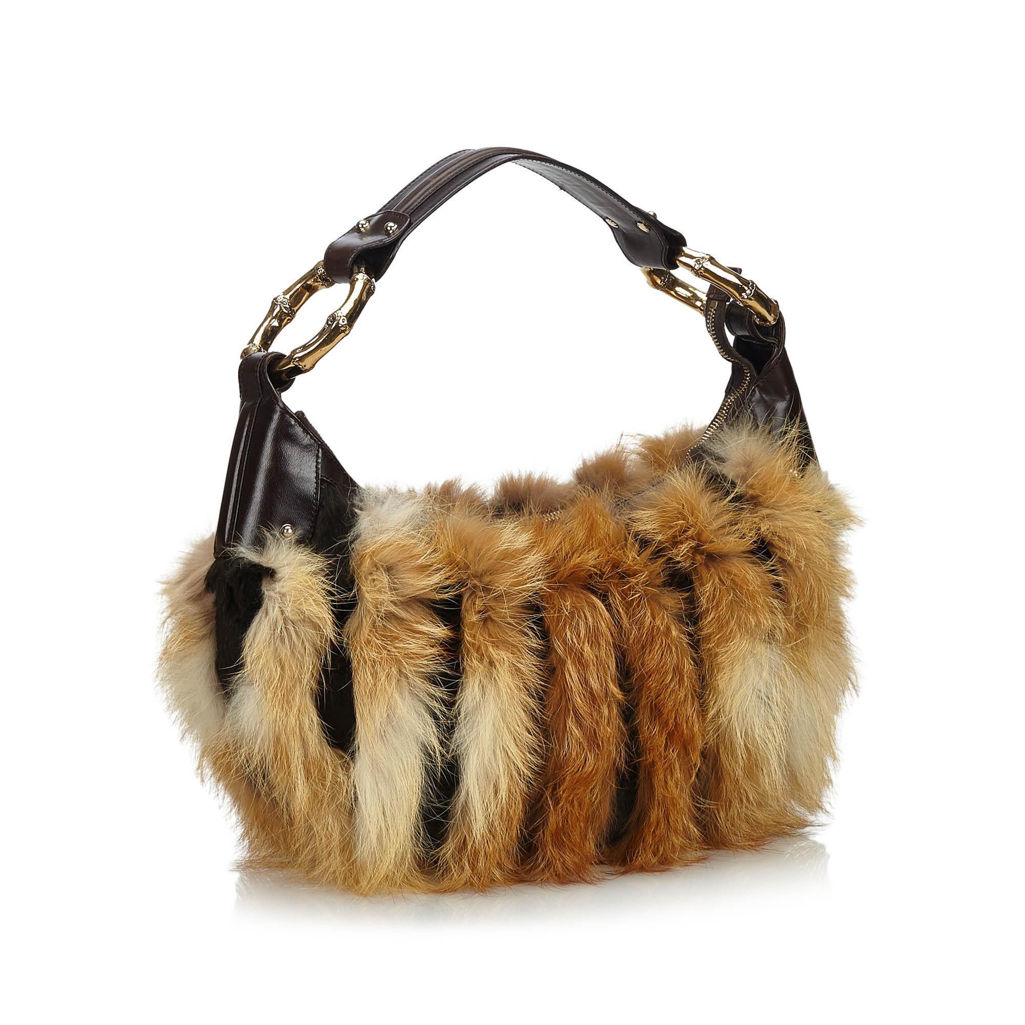 This hobo bag features a leather body with fur trim, a flat leather strap with bamboo detail, a top zip closure, and an interior zip pocket. It carries as AB condition rating.

Inclusions: 
Dust Bag

Dimensions:
Length: 24.00 cm
Width: 25.00