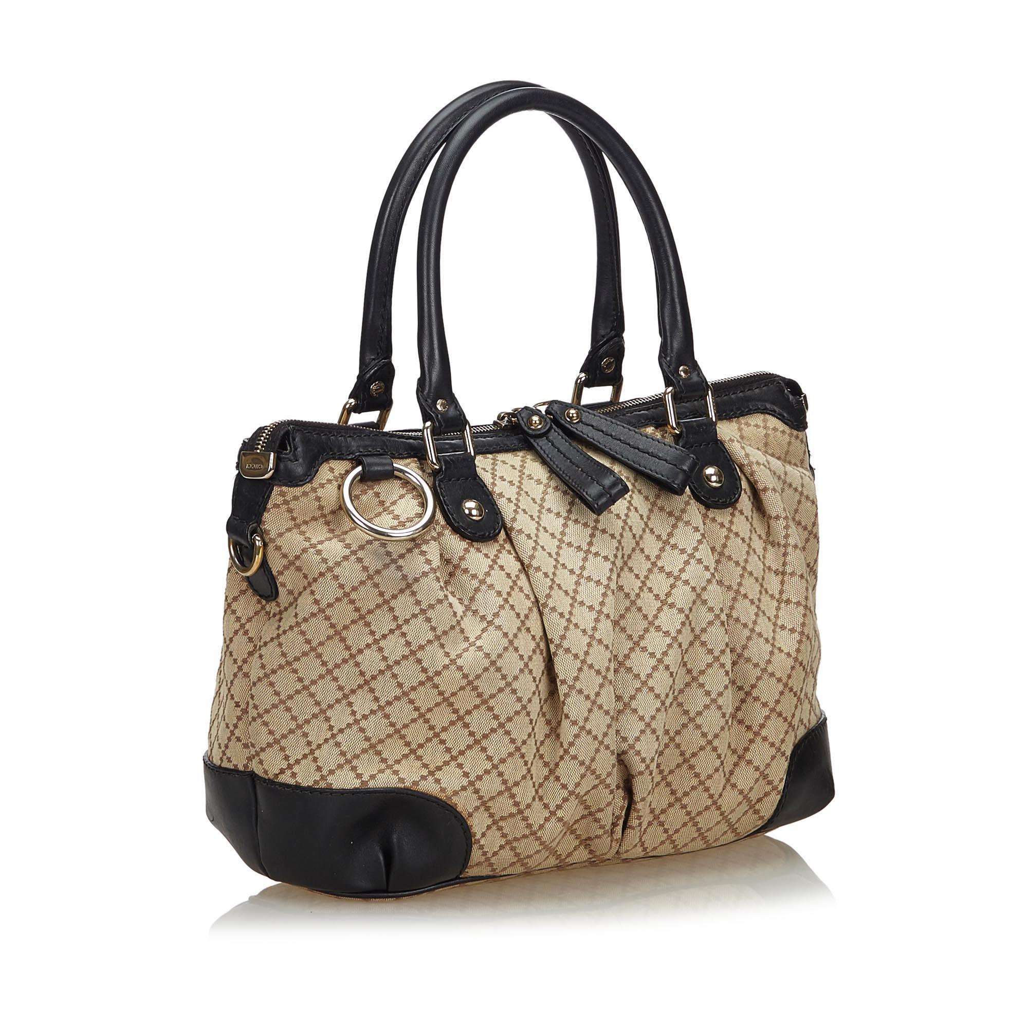 This Sukey features a canvas body with leather trim, rolled leather handles, flat leather strap, top zip closure, and interior zip and slip pockets. It carries as B+ condition rating.

Inclusions: 
This item does not come with