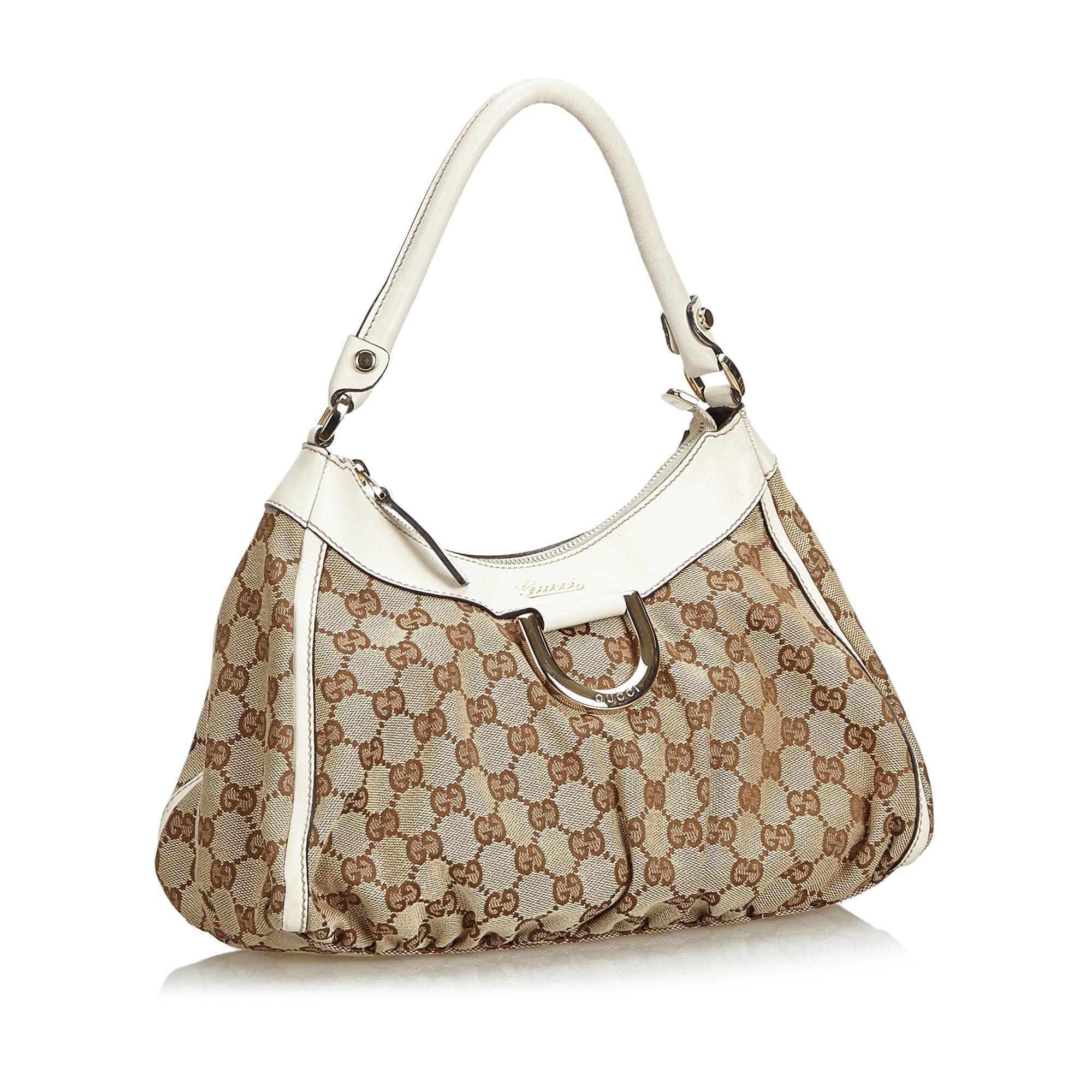 The Abbey D-Ring handbag features a jacquard body with leather trim, a rolled leather handle, a top zip closure, fabric lining, and an interior zip and slip pockets. It carries as B+ condition rating.

Inclusions: 
Dust Bag
Dimensions:
Length: 23.00
