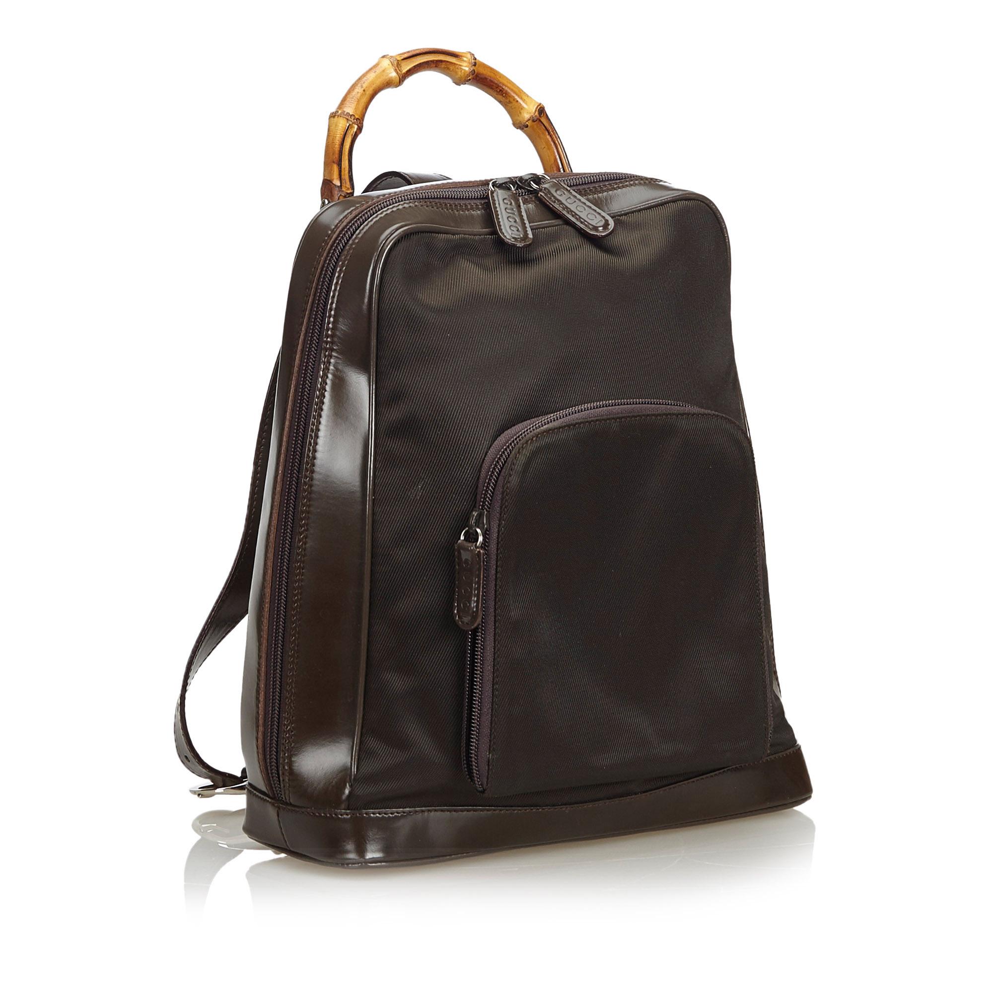 This backpack features a nylon body with leather trim, a front exterior zip pocket, a bamboo top handle, a single adjustable shoulder strap, a top zip closure, and an interior zip pocket. It carries as B+ condition rating.

Inclusions: 
This item