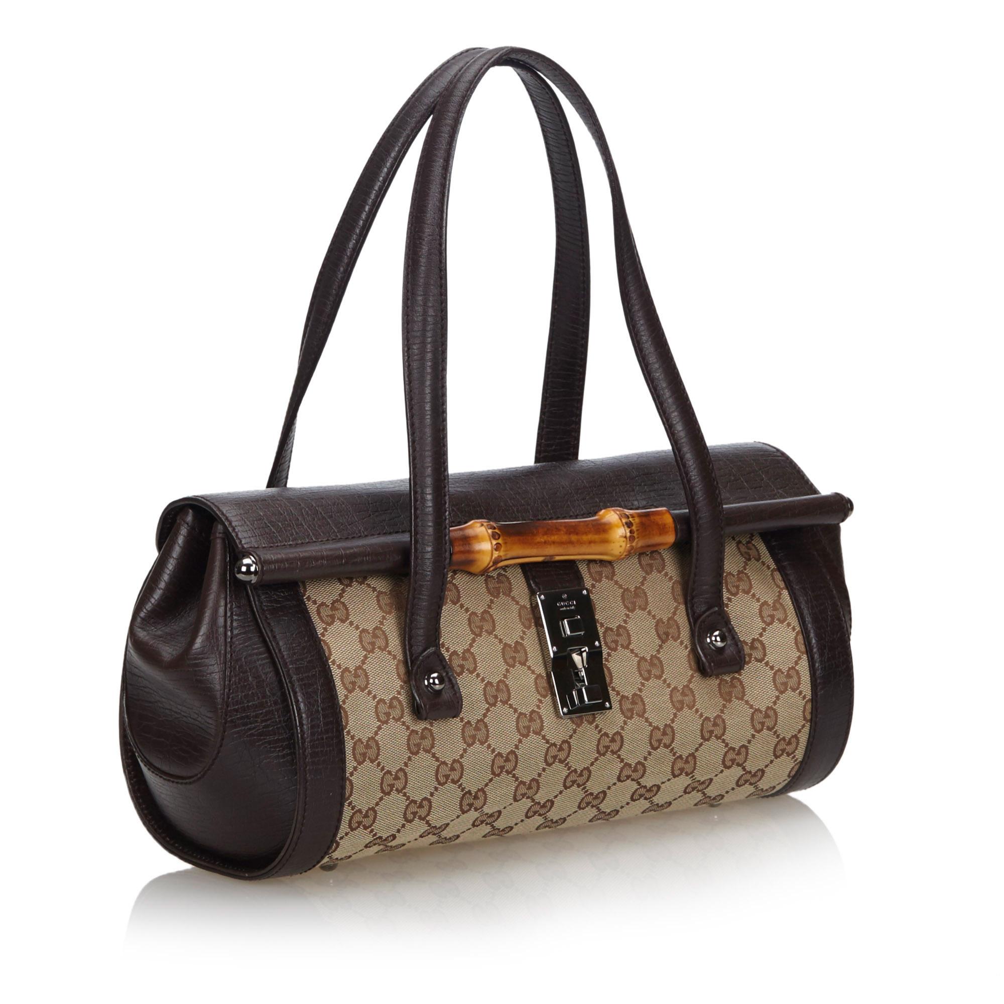 The Bamboo Bullet shoulder bag features a canvas body with leather trim, flat leather handles, a front flap with push lock closure, and an interior zip pocket. It carries as AB condition rating.

Inclusions: 
This item does not come with