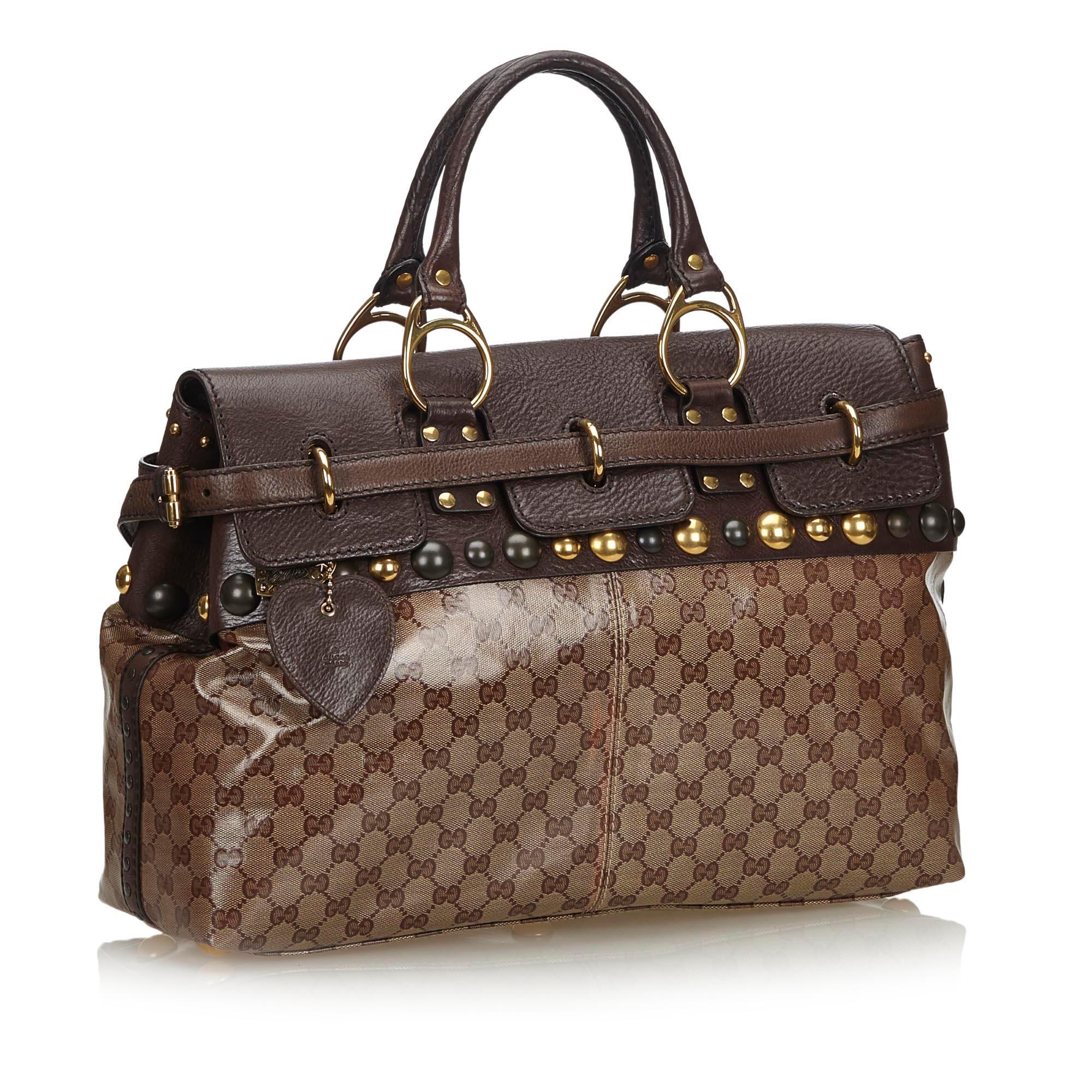 The Babouska handbag features a coated canvas body with leather trim and stud details, rolled leather handles, a front flap, and interior zip and slip pockets. It carries as B+ condition rating.

Inclusions: 
Dust Bag

Dimensions:
Length: 30.00