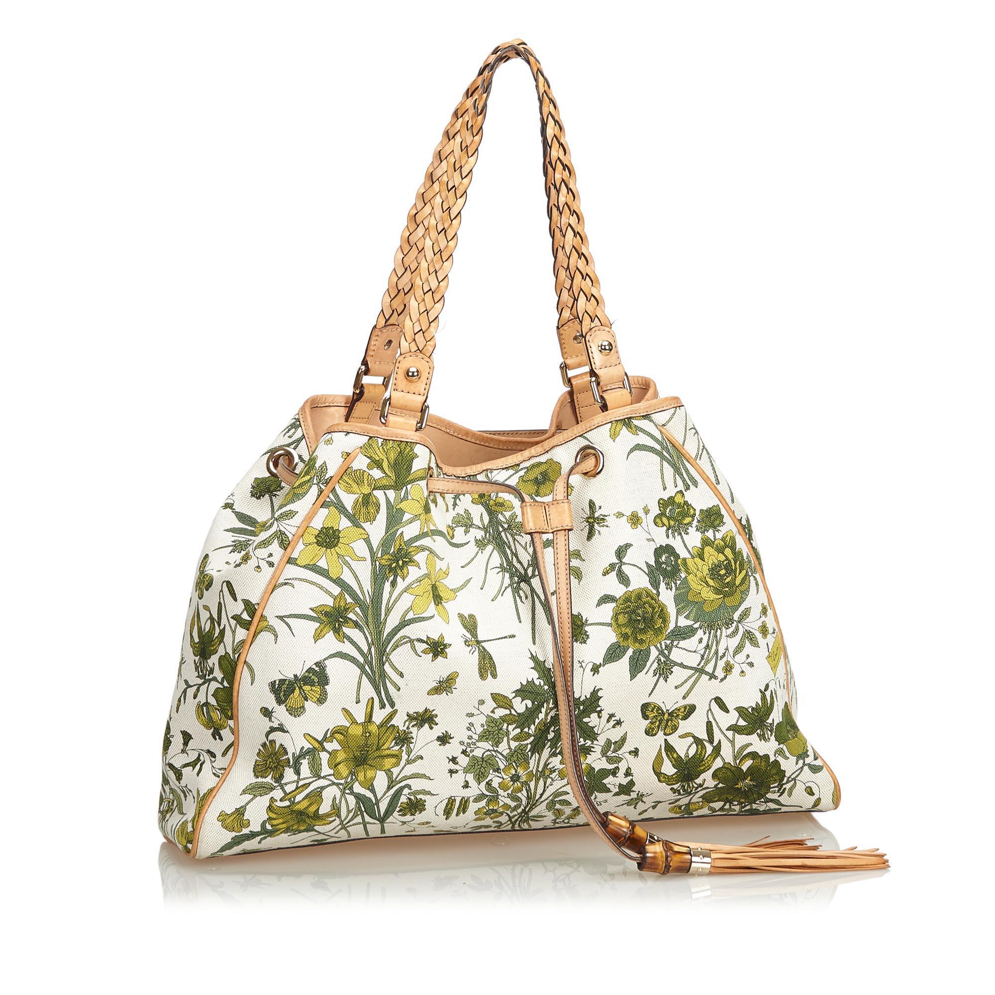 The Flora tote bag features a canvas body, flat leather braided straps, an open top with a draw string tassel closure, and an interior zip pocket. It carries as B condition rating.

Inclusions: 
Dust Bag

Dimensions:
Length: 30.00 cm
Width: 42.00