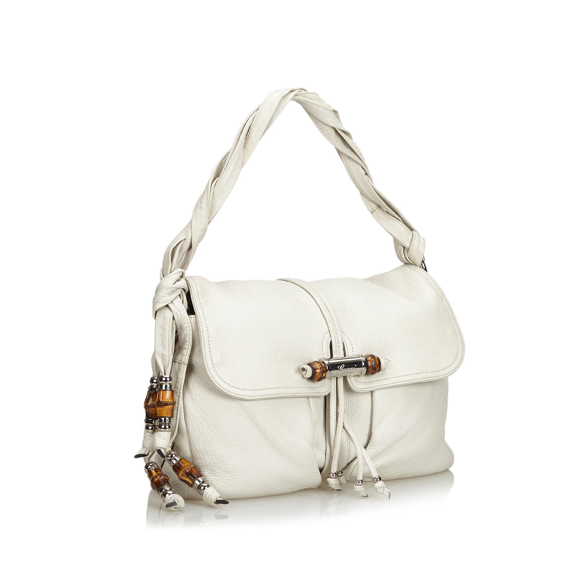 The Jungle shoulder bag features a leather body with bamboo detail, twisted leather handles, a detachable chain strap, a top flap with a magnetic closure, and interior zip and slip pockets. It carries as B condition rating.

Inclusions: 
This item