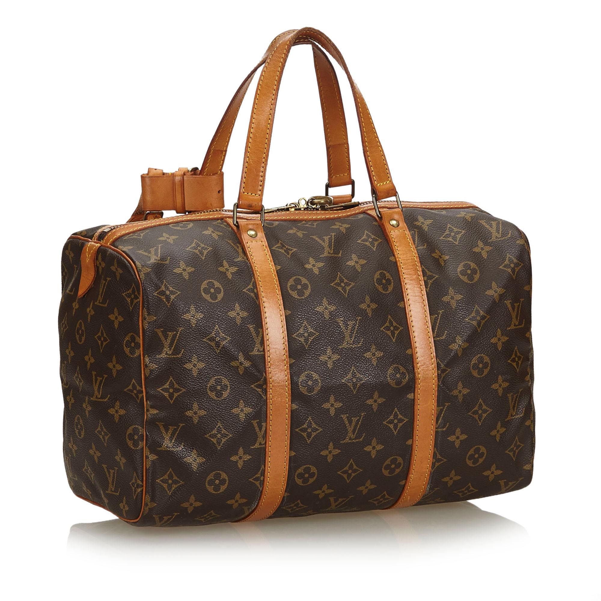 The Sac Souple 35 features a monogram canvas body, flat leather straps, and a top zip closure. It carries as B condition rating.

Inclusions: 
Padlock

Louis Vuitton pieces do not come with an authenticity card please refer to the production date