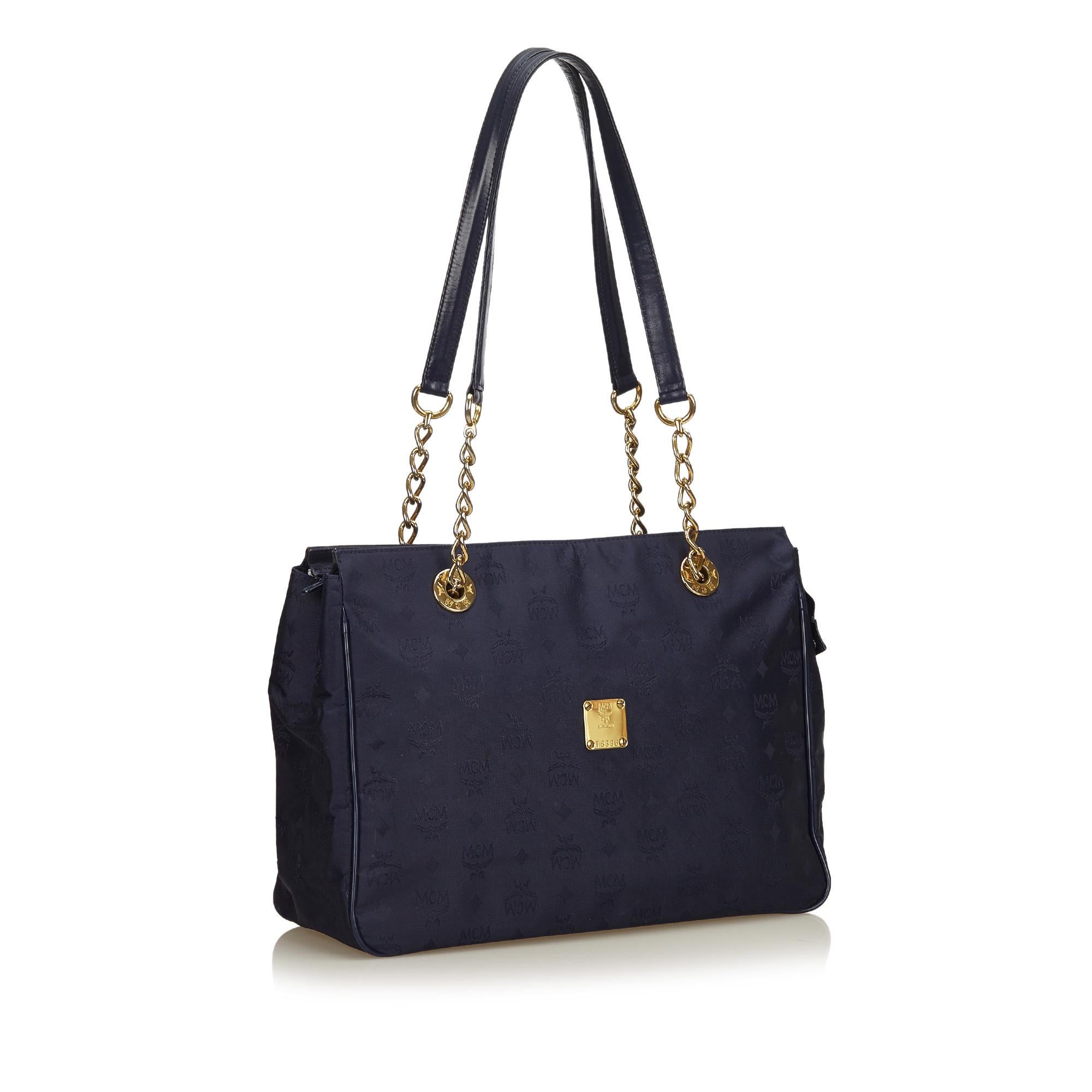 This shoulder bag features a nylon body, flat leather straps with gold-tone chains, top zip closure, and interior slip pockets. It carries as AB condition rating.

Inclusions: 
Dust Bag

Dimensions:
Length: 27.00 cm
Width: 39.00 cm
Depth: 14.00