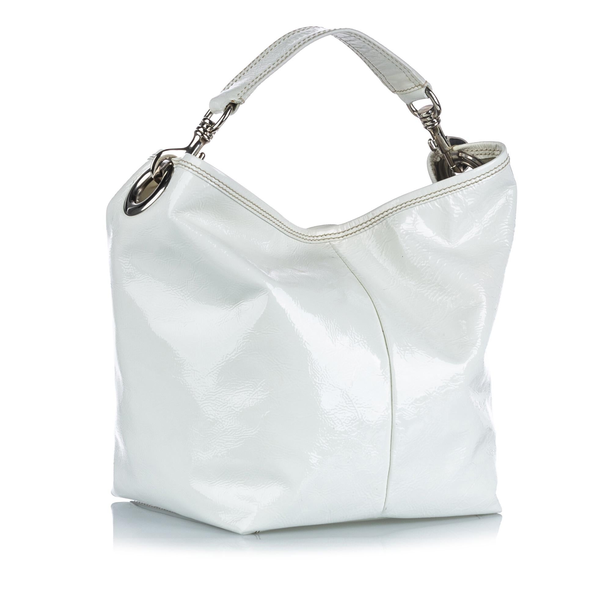 This shoulder bag features a patent leather body, a flat leather strap, an open top with a magnetic snap button closure, and an interior zip pocket. It carries as AB condition rating.

Inclusions: 
Dust Bag
Dimensions:
Length: 28.00 cm
Width: 32.00