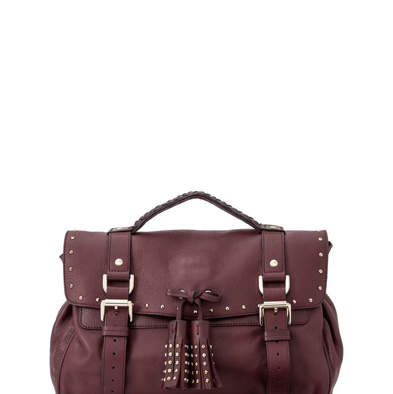 The Alexa features a leather body with belt details, a detachable adjustable shoulder strap, gold-tone hardware, a braided top handle, a front flap with a twist-lock closure and tassel detail, and interior zip and slip pockets. It carries as AB
