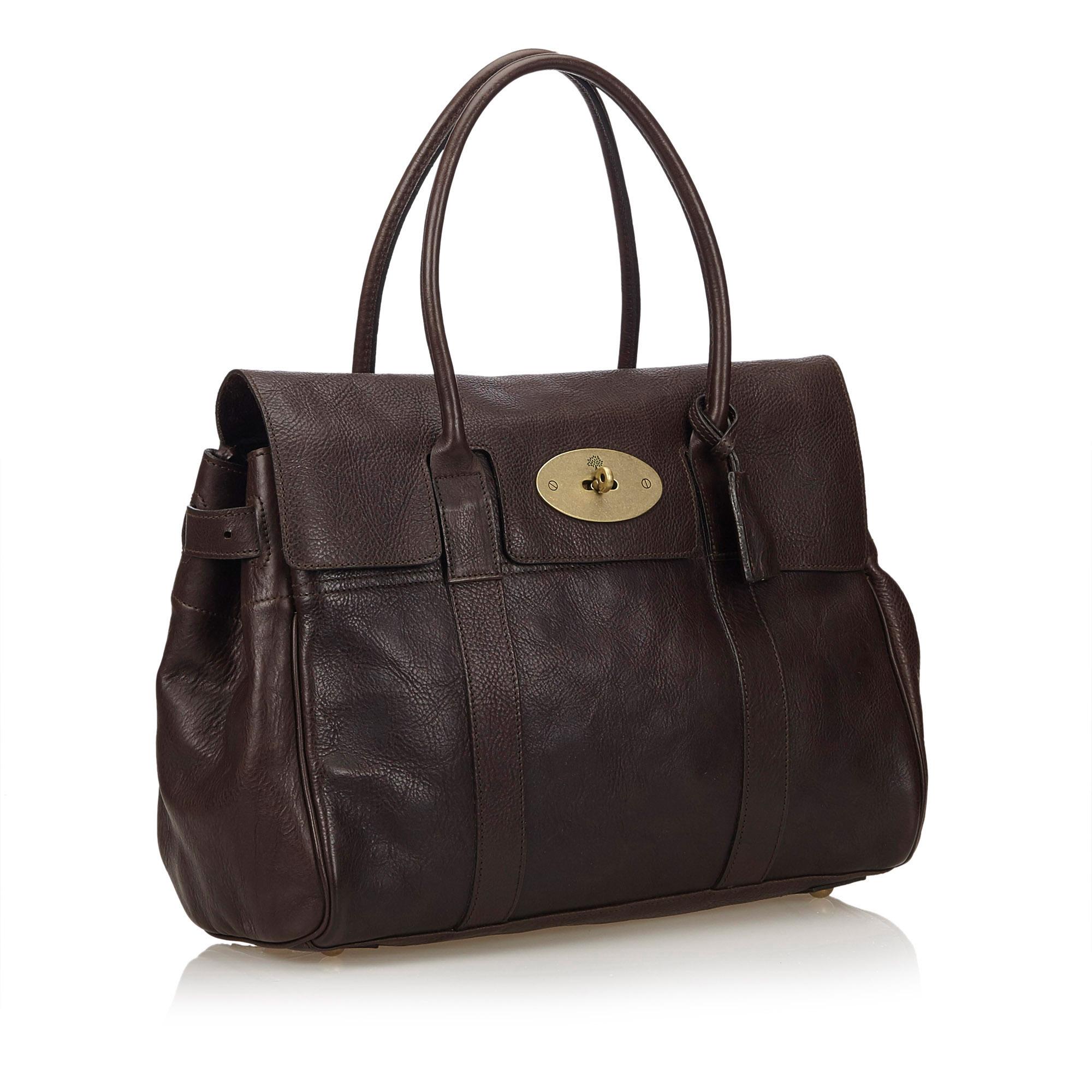The Bayswater features a leather body, rolled handles, a front flap with a twist lock closure, adjustable belt details on the sides, metal feet, and an interior zip pocket. It carries as B condition rating.

Inclusions: 
Dust