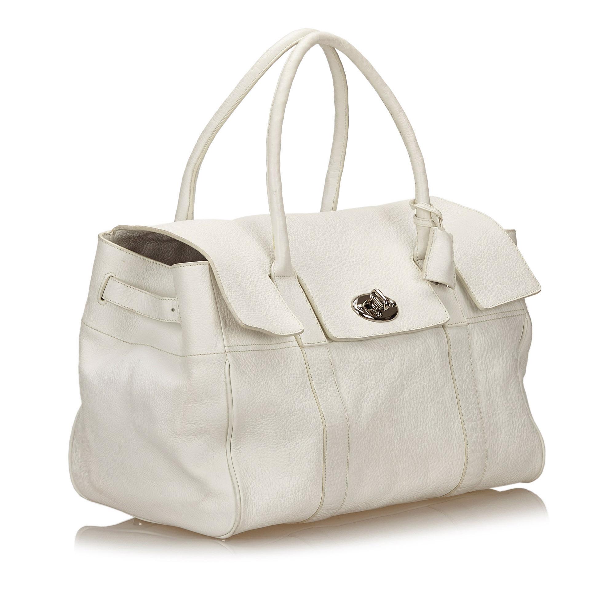 The Bayswater features a leather body, rolled handles, a front flap with a twist lock closure, adjustable belt details on the sides, metal feet, and an interior zip pocket. It carries as B condition rating.

Inclusions: 
Dust