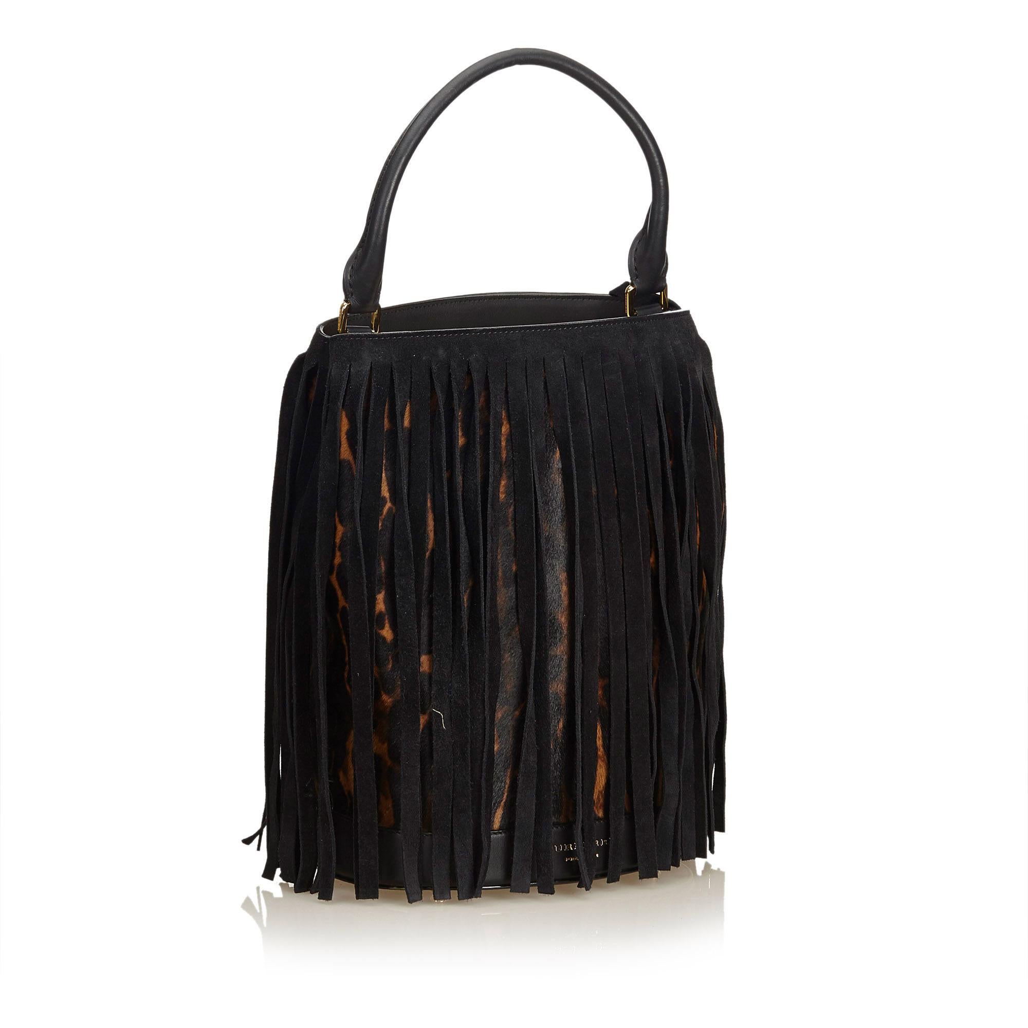 This handbag features a leopard print harako body with suede fringe detail, rolled leather handle, open top, and interior slip pocket. It carries as AB condition rating.

Inclusions: 
Dust Bag

Dimensions:
Length: 37.00 cm
Width: 26.00 cm
Depth: