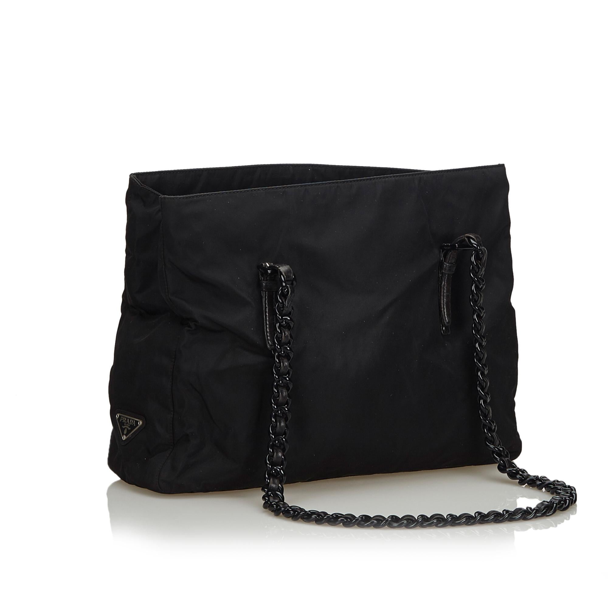This tote bag features a nylon body, plastic chain straps, an open top, an interior zip compartment, and an interior zip pocket. It carries as B+ condition rating.

Inclusions: 
Authenticity Card

Dimensions:
Length: 26.00 cm
Width: 35.00 cm
Depth: