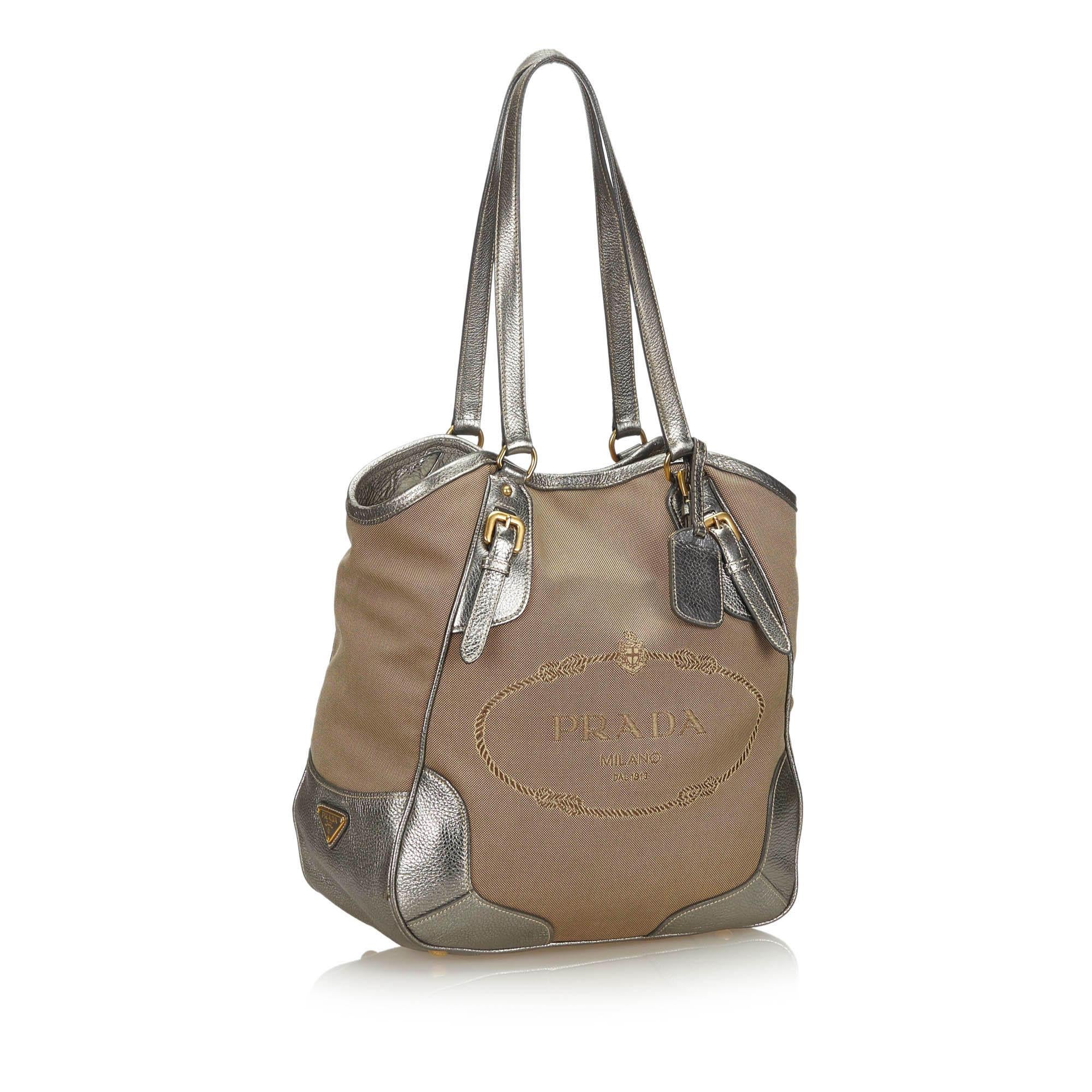 This tote bag features a canvas body with leather trim, flat leather straps, an open top with magnetic snap closure, and interior zip and slip pockets. It carries as AB condition rating.

Inclusions: 
Dust Bag

Dimensions:
Length: 34.00 cm
Width: