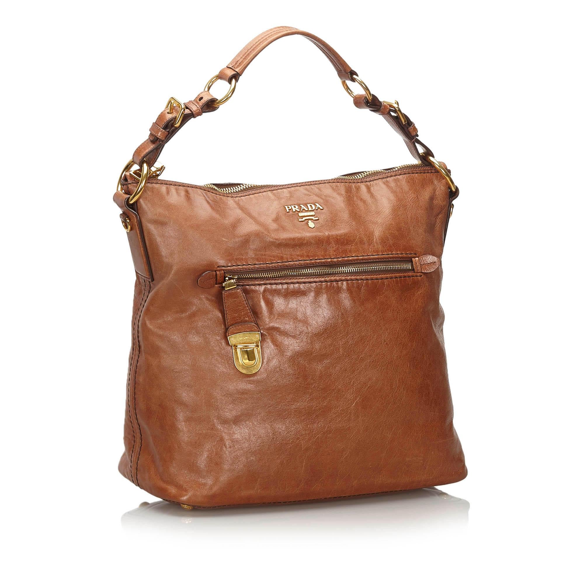 This shoulder bag features a leather body, front and back exterior zip pockets, a flat leather handle, a top zip closure, and interior zip and slip pockets. It carries as B+ condition rating.

Inclusions: 
This item does not come with
