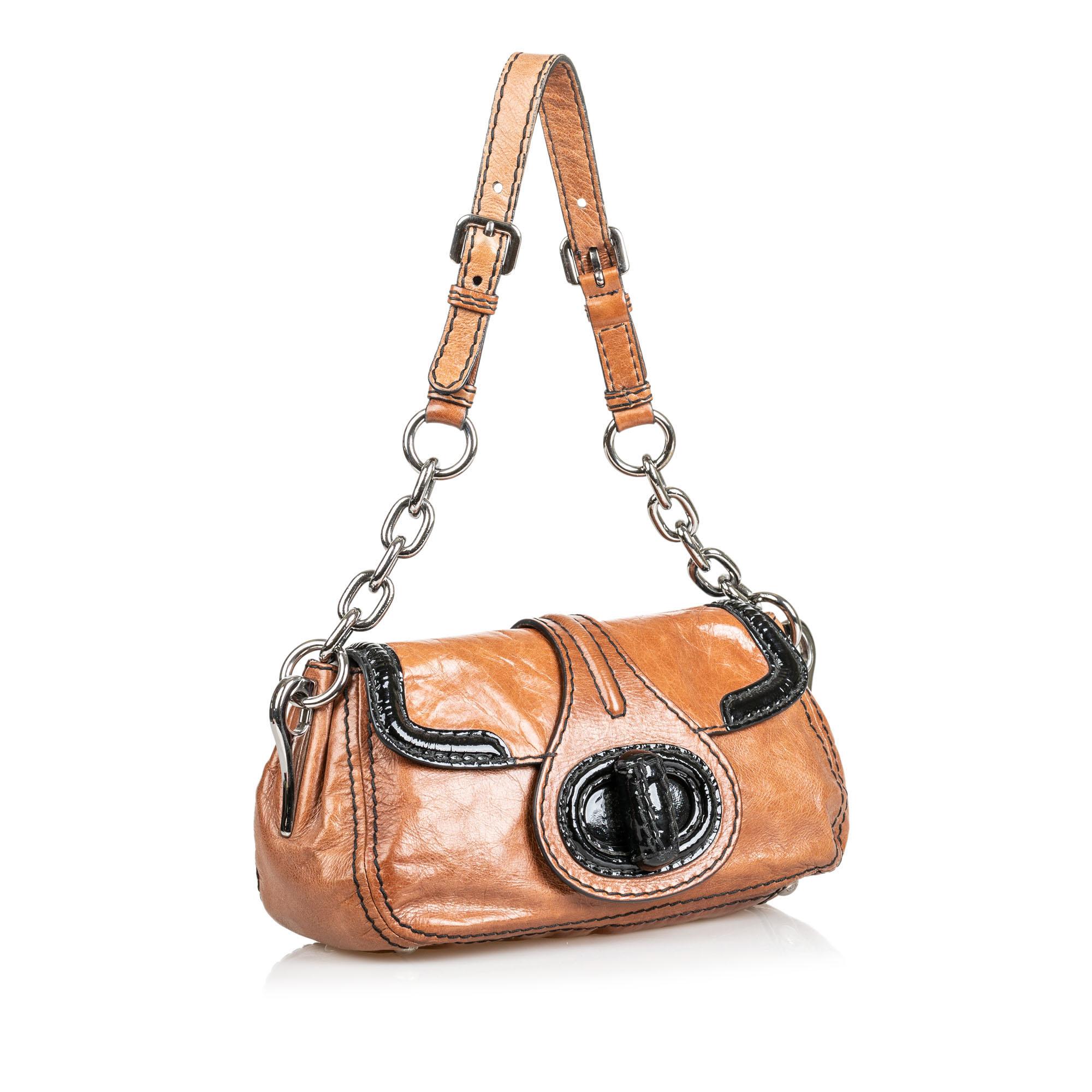 This shoulder bag features a leather body, a flat strap with silver tone chain, a top flap with turn lock closure, and interior zip and slip pockets. It carries as B condition rating.

Inclusions: 
This item does not come with