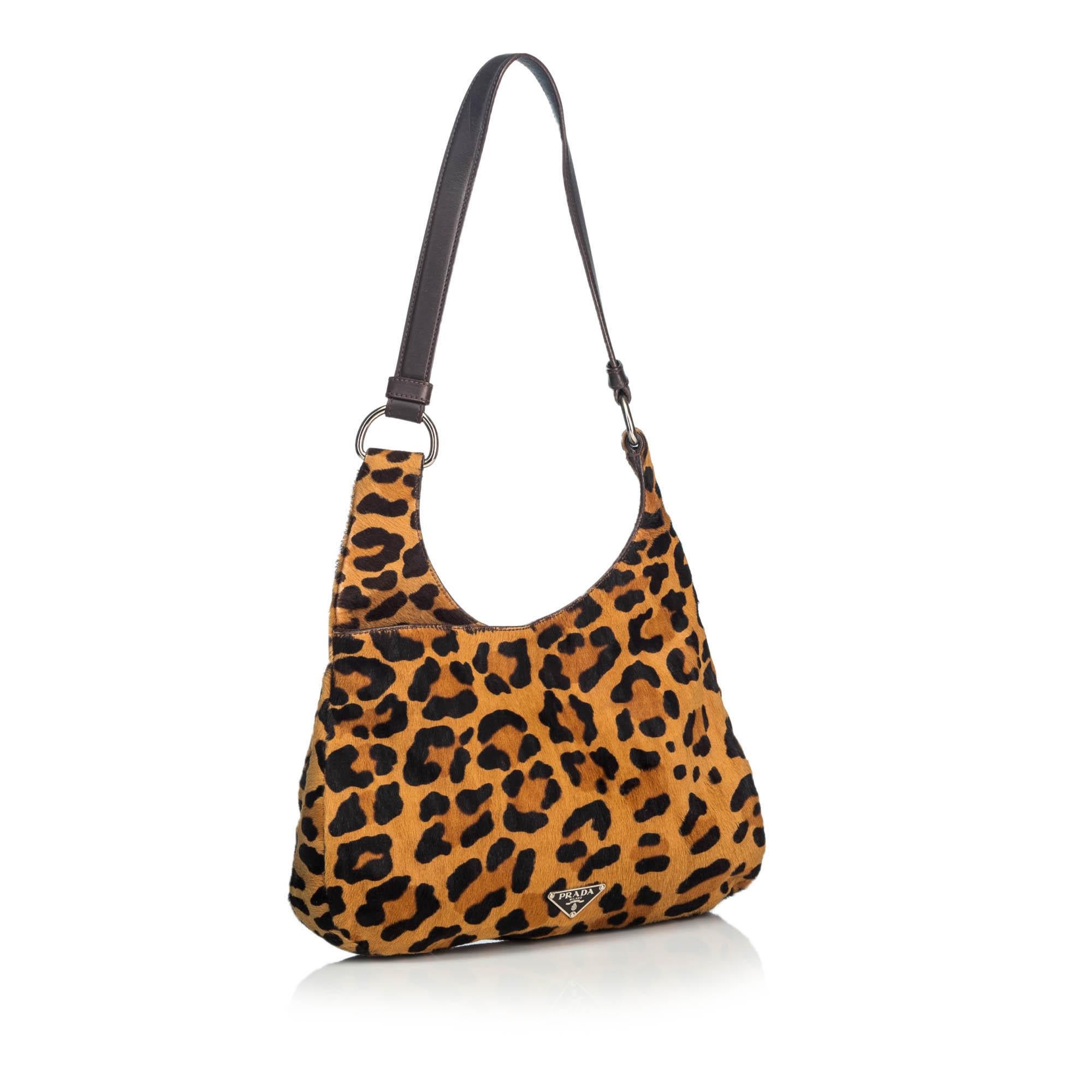 This hobo bag features a leopard print ponyhair body, a flat leather strap, an open top with a push lock closure, and an interior zip pocket It carries as B+ condition rating.

Inclusions: 
This item does not come with