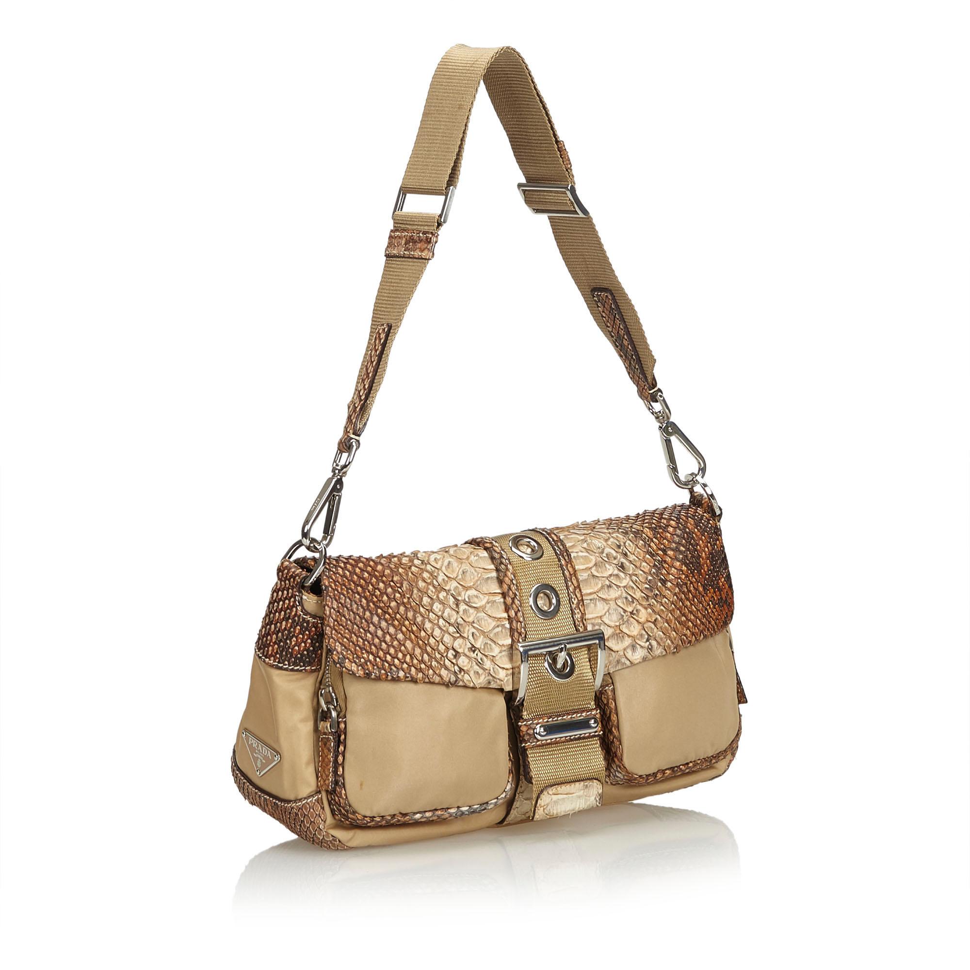 This shoulder bag features a nylon body with python leather trim, front exterior compartments, a top flap with a buckle closure, an open top, and an interior zip pocket. It carries as AB condition rating.

Inclusions: 
Dust Bag
Dimensions:
Length: