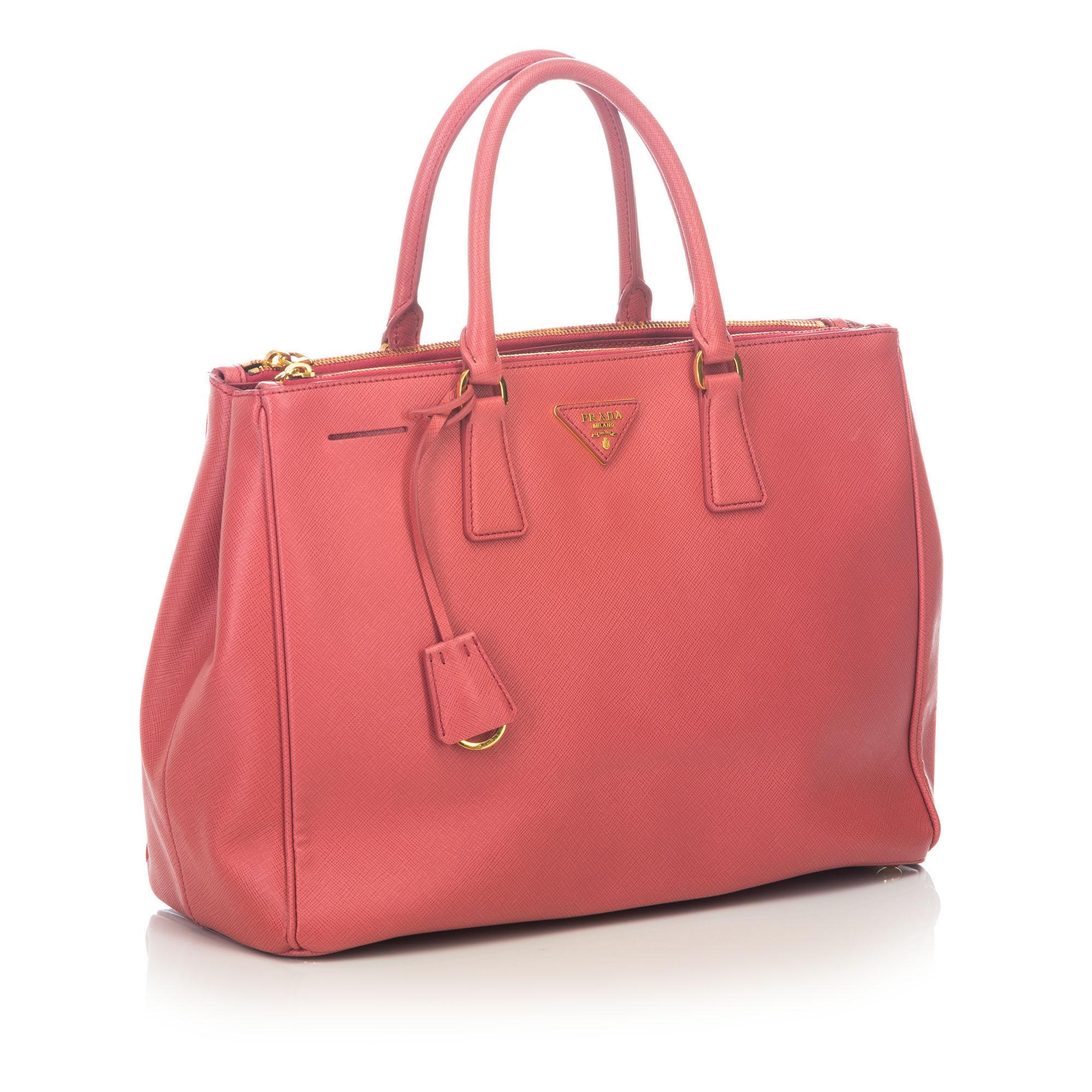 This tote features a saffiano leather body, rolled handles, zip compartments, an open top, and an interior zip pocket. It carries as AB condition rating.

Inclusions: 
This item does not come with inclusions.

Dimensions:
Length: 25.50 cm
Width: