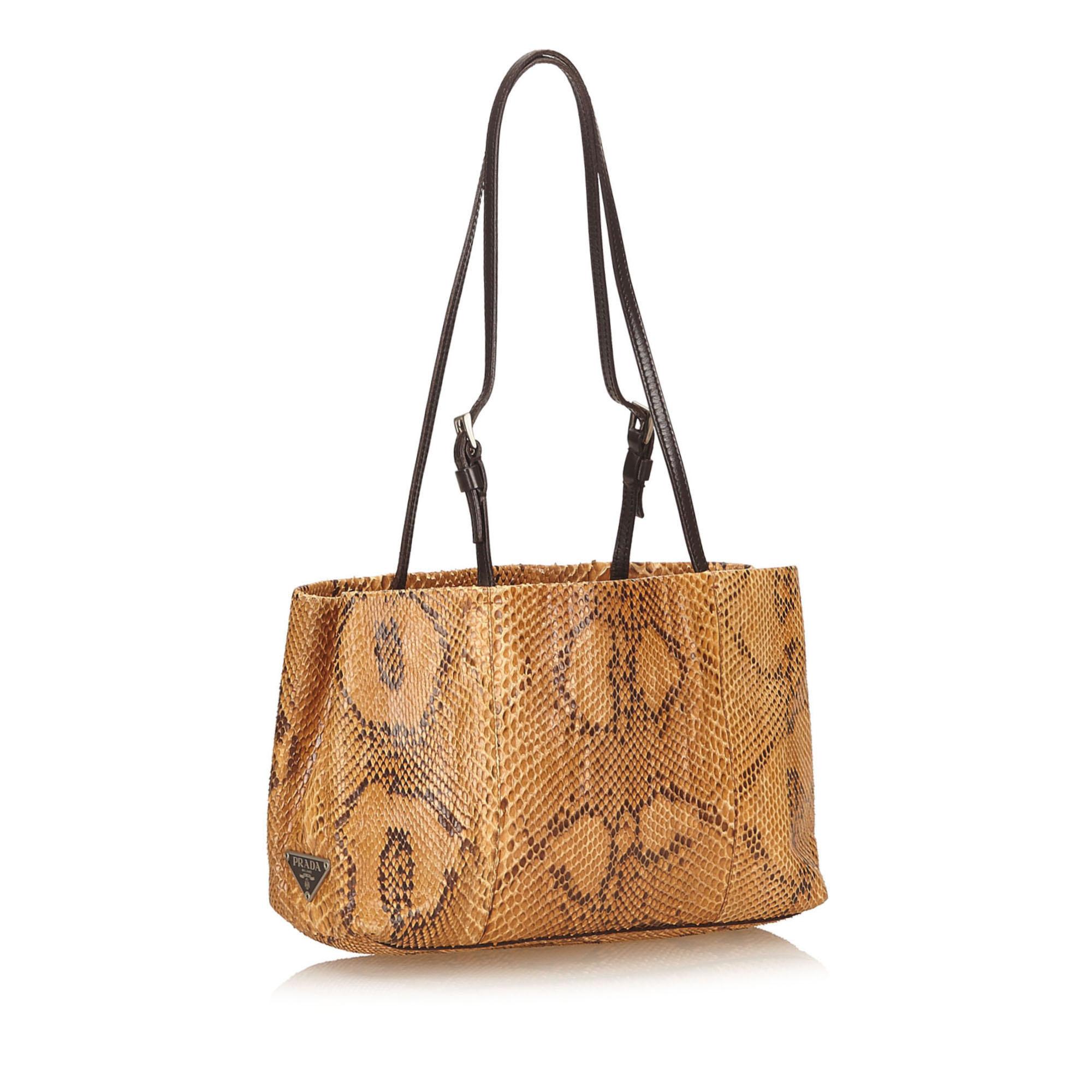 This shoulder bag features a python leather body, flat leather straps, open top, interior zip compartment, and interior zip and slip pocket. It carries as B condition rating.

Inclusions: 
This item does not come with