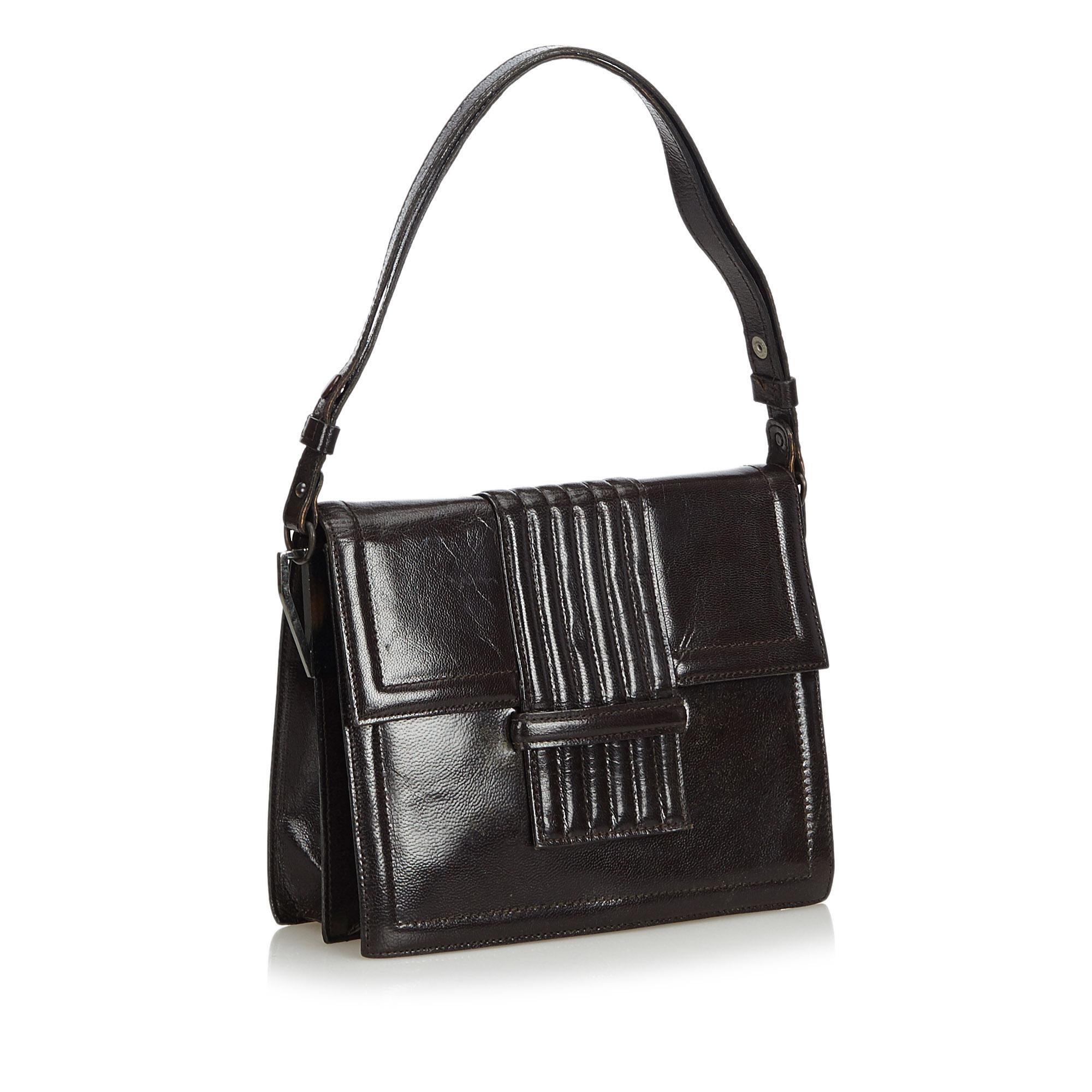 This shoulder bag features a leather body, a flat strap, a front flap with a pull through closure, and interior zip and slip pockets. It carries as B condition rating.

Inclusions: 
This item does not come with inclusions.

Dimensions:
Length: 19.00