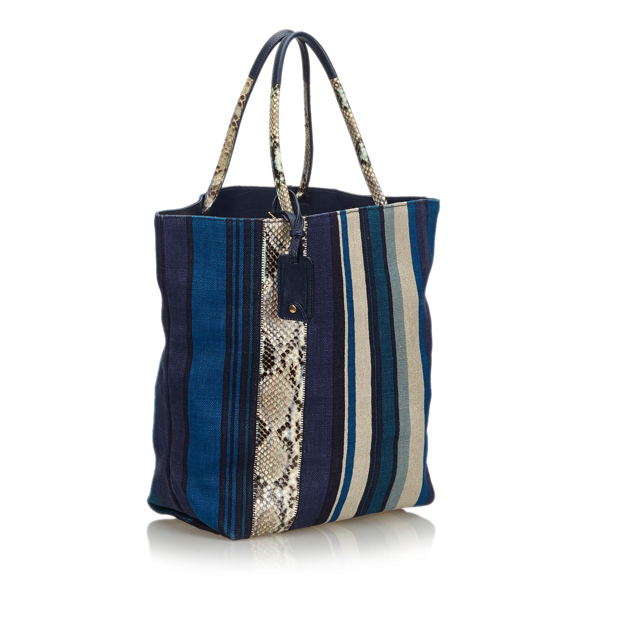 This tote bag features a printed canvas body with a python leather trim, flat leather handles, an open top, an interior zip pocket. It carries as AB condition rating.

Inclusions: 
This item does not come with inclusions.

Dimensions:
Length: 35.00