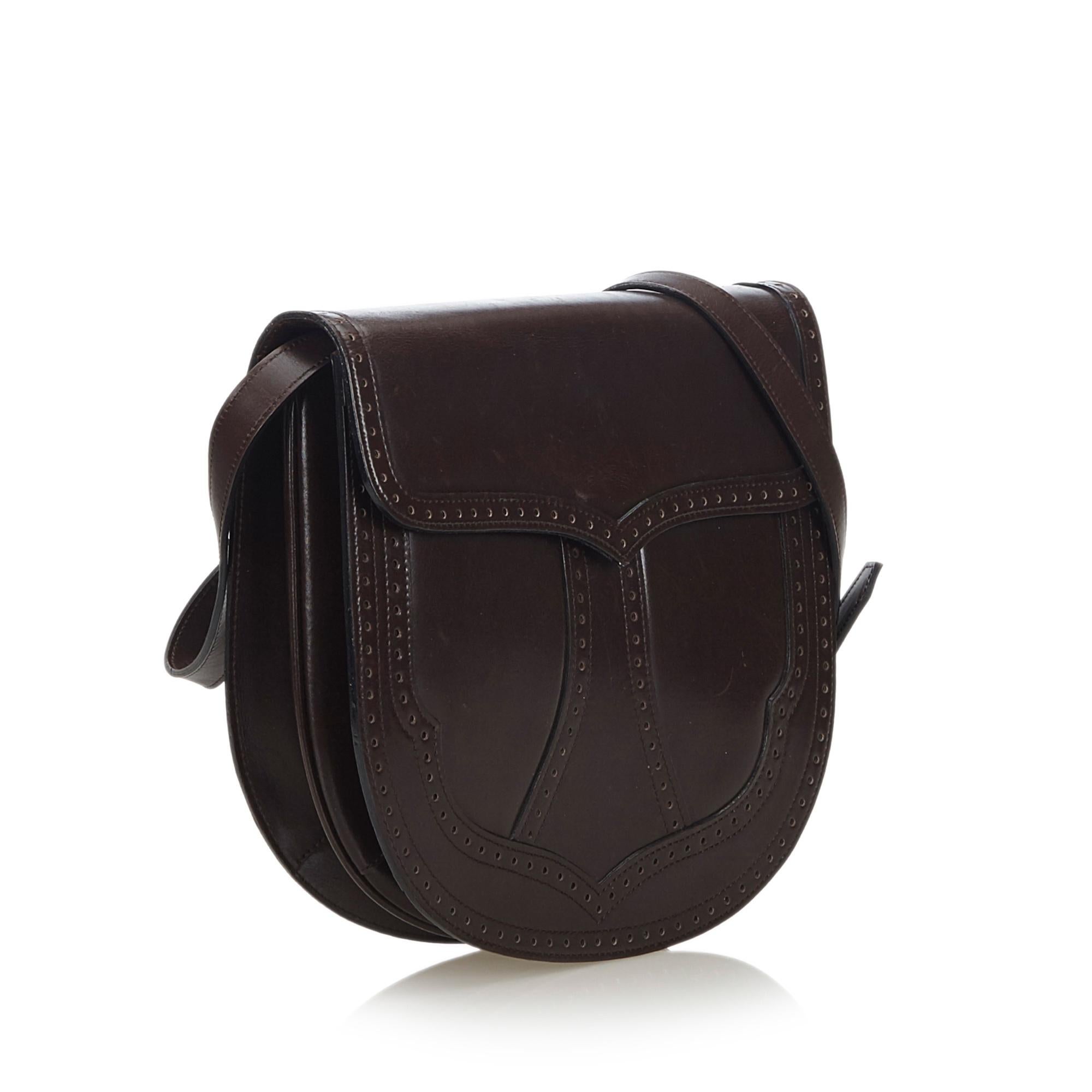 This crossbody bag features a leather body, a flat strap, a front flap magnetic snap button closure, and interior zip and slip pockets. It carries as B+ condition rating.

Inclusions: 
This item does not come with inclusions.

Dimensions:
Length: