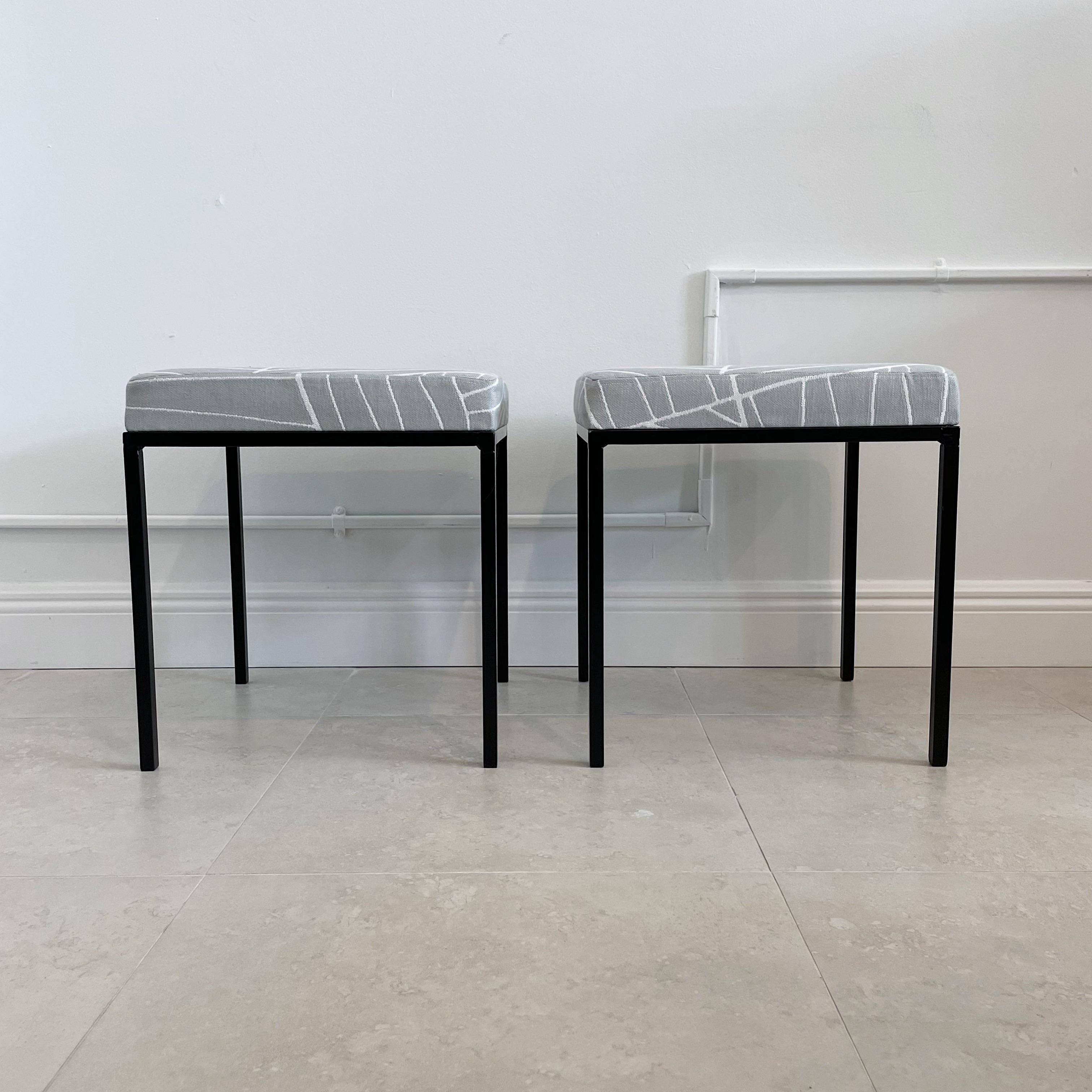 These are iron stools from the 1950s, which have been recently powder-coated in black and reupholstered with abstract palm frond outdoor fabric. The design of these stools is credited to Daryl Landrum for Avard, and they are reminiscent of the style