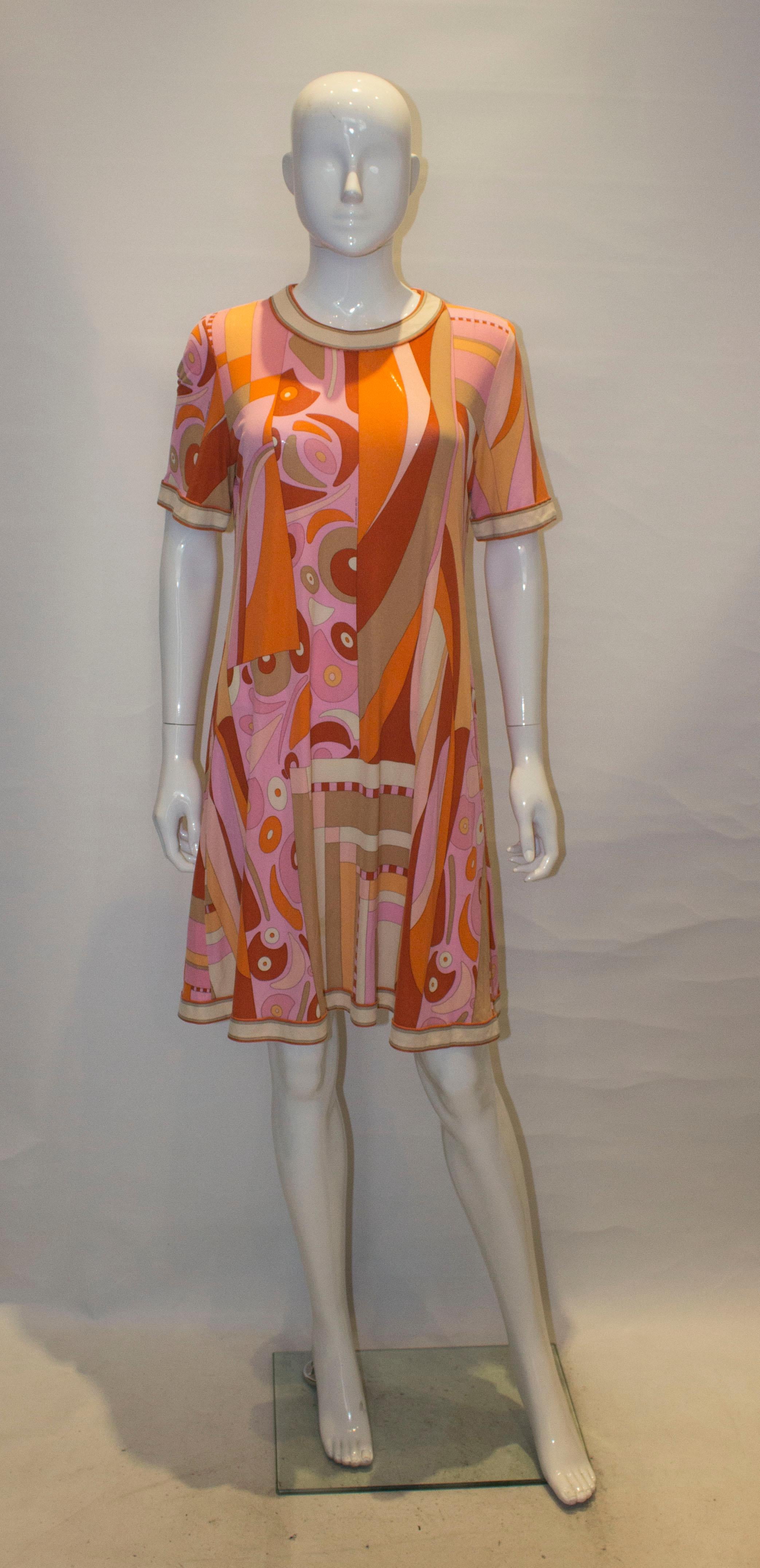 A colourful and easy to wear vintage silk jersey dress from Averrardo Bessi. In shades of pink, orange and biscuit. , the dress has a round neckline, central back zip and broder along the hem and sleaves.