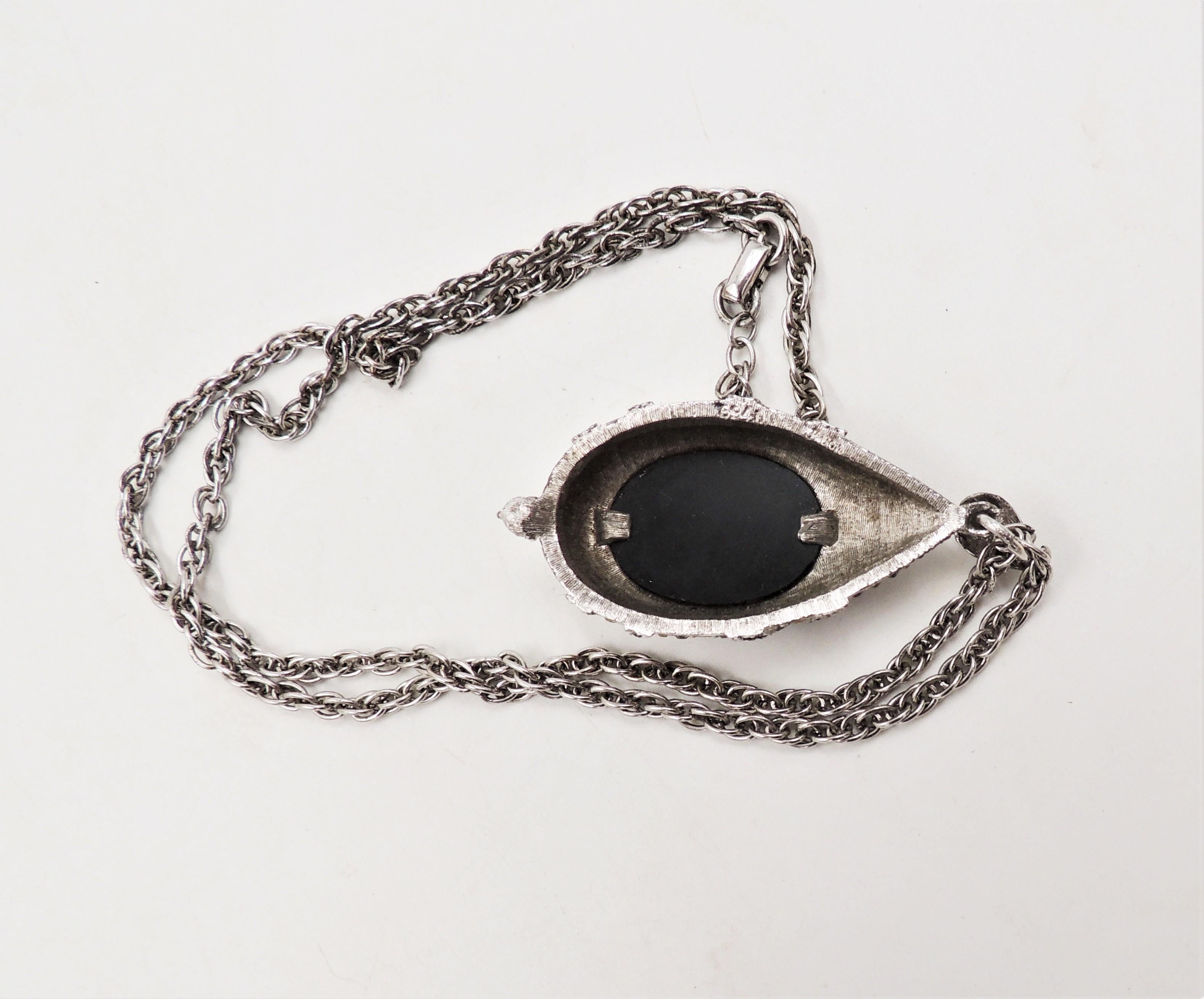 1960s brushed silvertone with cabochon faux-hematite with small faux-hematite and clear rhinestone accents pendant necklace with fold over clasp. Marked 