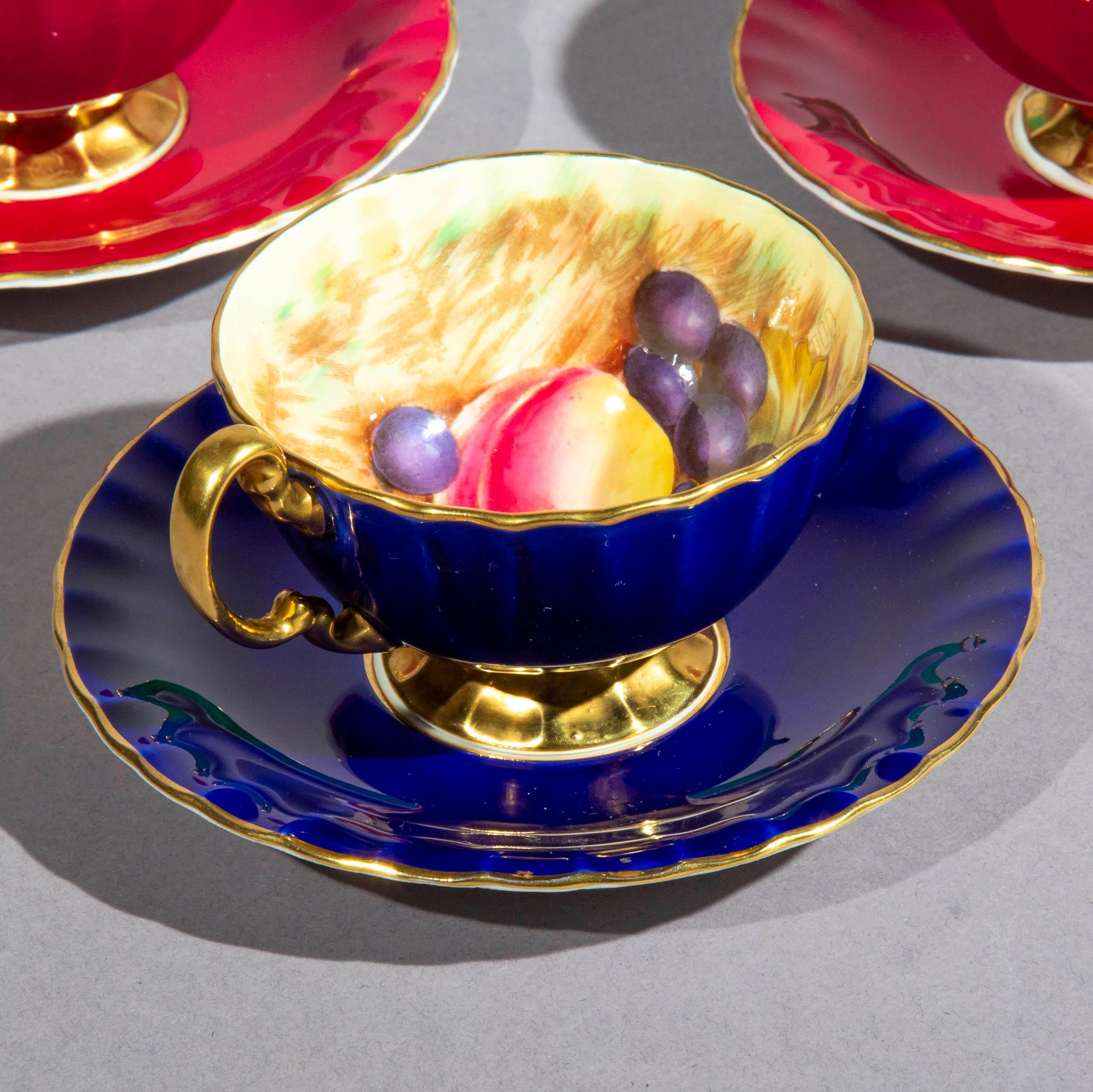 A fabulously decorative harlequin set of eleven vintage Aynsley porcelain tea cups and saucers, in multicoloured glazes, hand-decorated and signed by the artists JA Bailey and D Jones.
England, circa 1950

Variously glazed in cobalt blue (1),